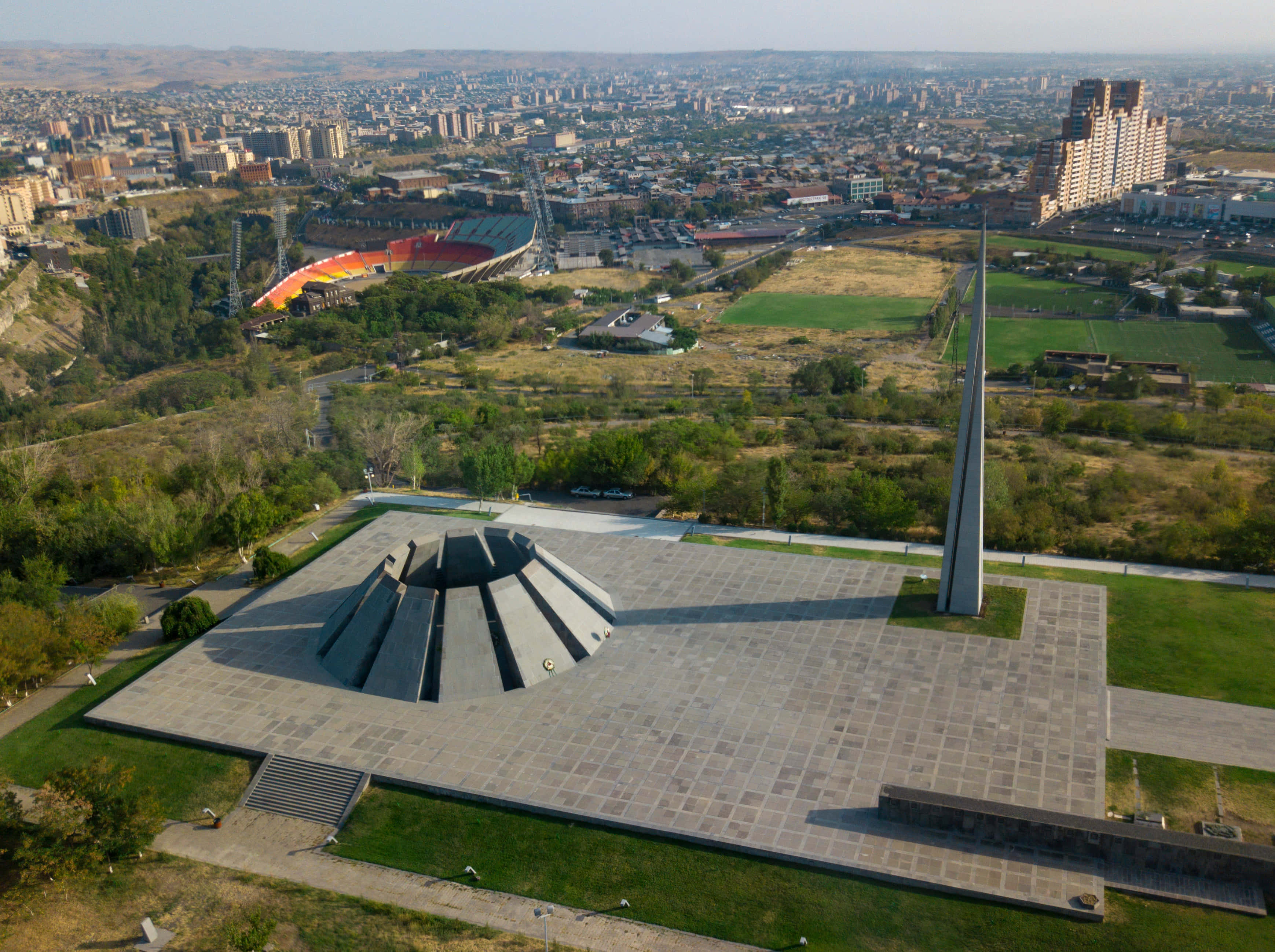 Memorial 桌布 壁紙 — 現代紀念建築群的鳥瞰圖，設有金字塔和尖塔，俯瞰城市景觀和體育場。