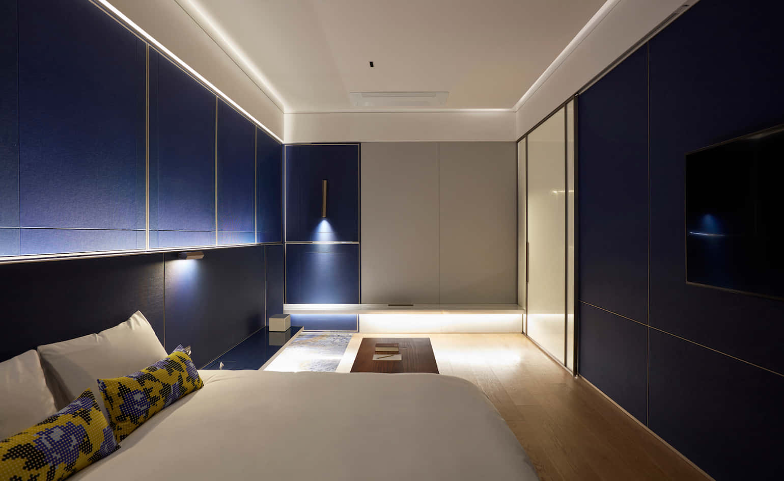 Hotel 桌布 壁紙 — 現代臥室，深藍色鑲板牆，隱藏式LED照明和木地板。