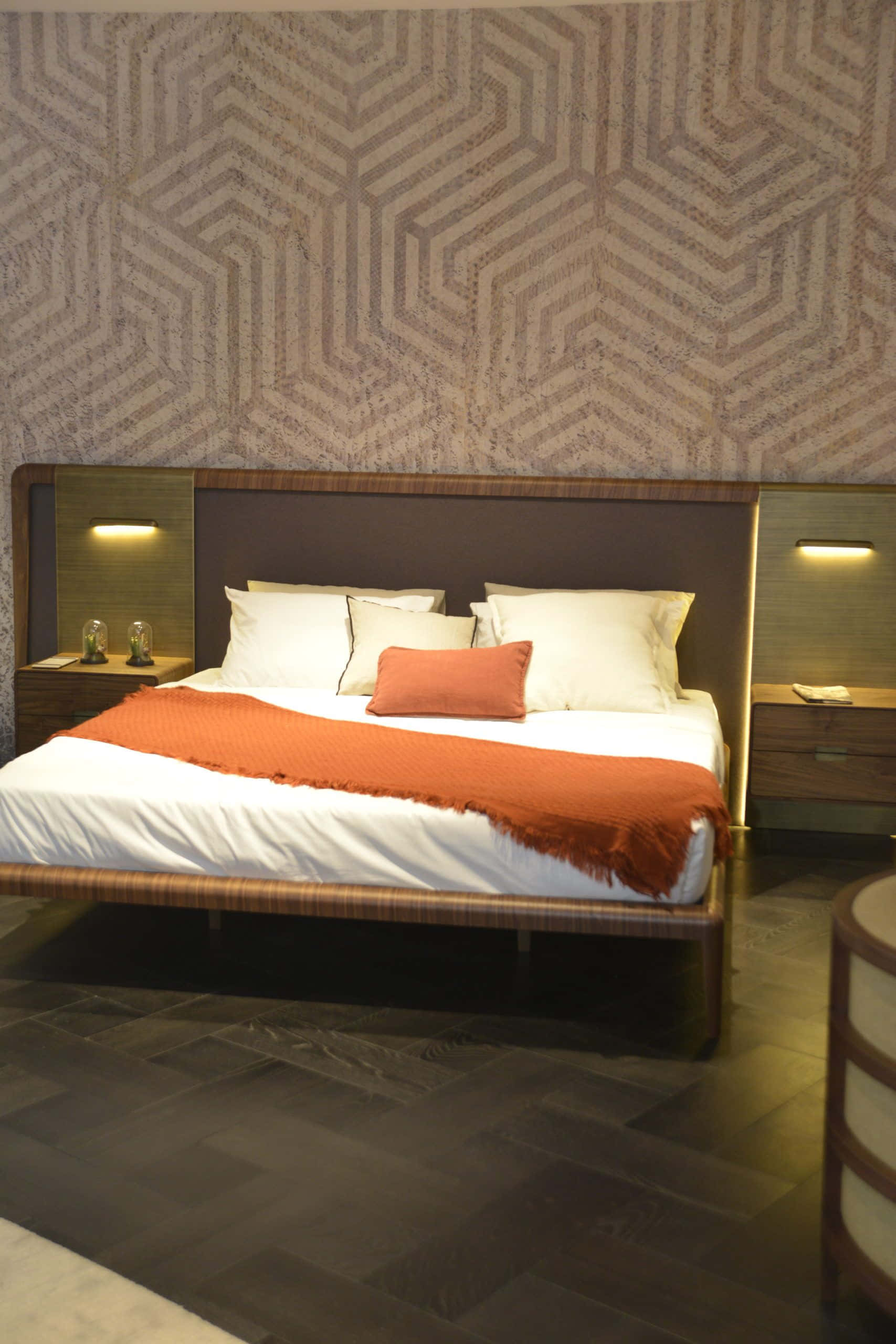 bed 桌布 壁紙 — 現代臥室以幾何圖案牆壁為背景，配備木床、白色床單和橙色裝飾毯。