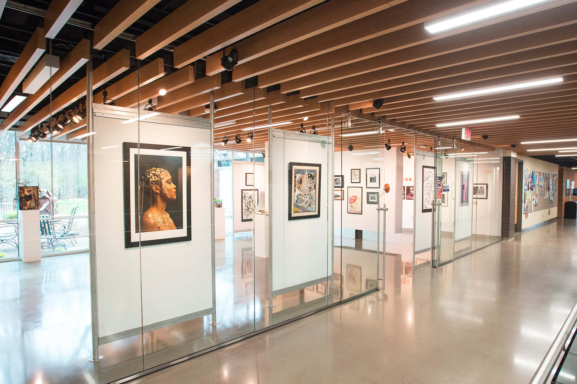 Exhibition 桌布 壁紙 — 現代藝術畫廊走廊，設有玻璃隔斷，在溫暖的木天花樑下展示裱框畫作。