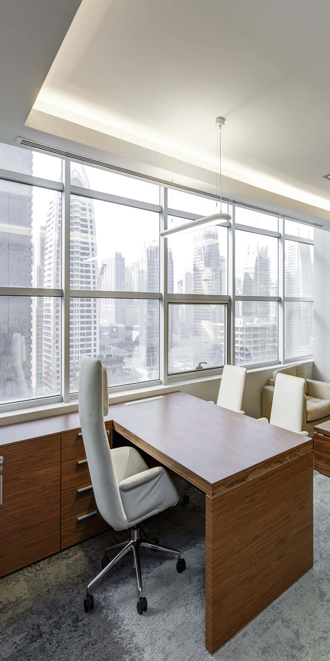 Pixel 3 Office 桌布 壁紙 — 現代辦公室，配有木製書桌和白色椅子，透過落地窗俯瞰明亮城市天際線。