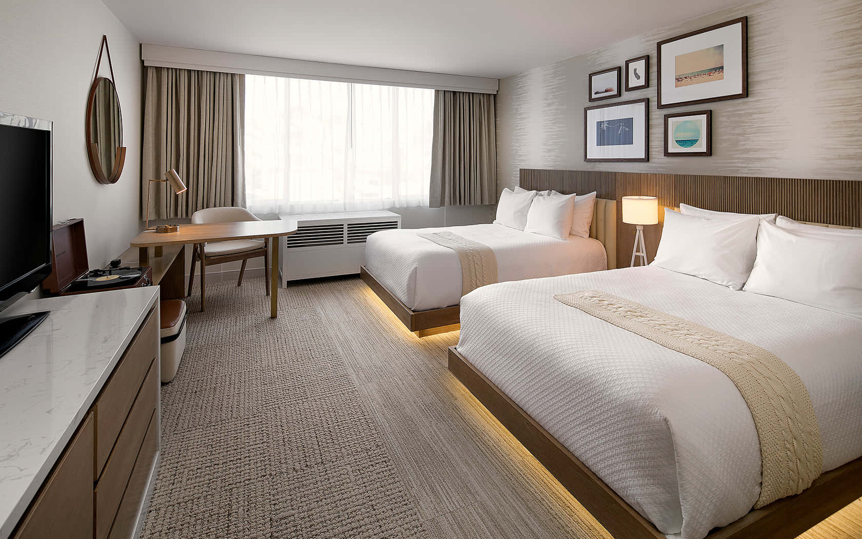 Hotel Room 桌布 壁紙 — 現代酒店客房，兩張整齊鋪好的床鋪，柔和環境燈光，紋理牆壁上掛有框藝術品。