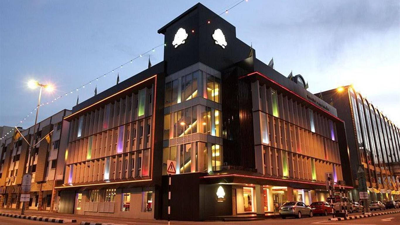 Hotel 桌布 壁紙 — 現代酒店建築在暮色天空下被五彩燈光照亮，街道旁停有汽車。