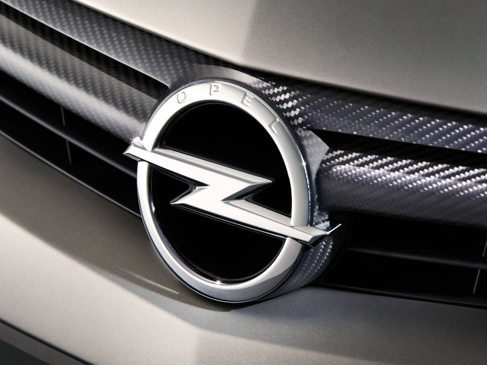 Opel 桌布 壁紙 — 現代銀色汽車的碳纖維格柵中央閃亮的歐寶標誌特寫。