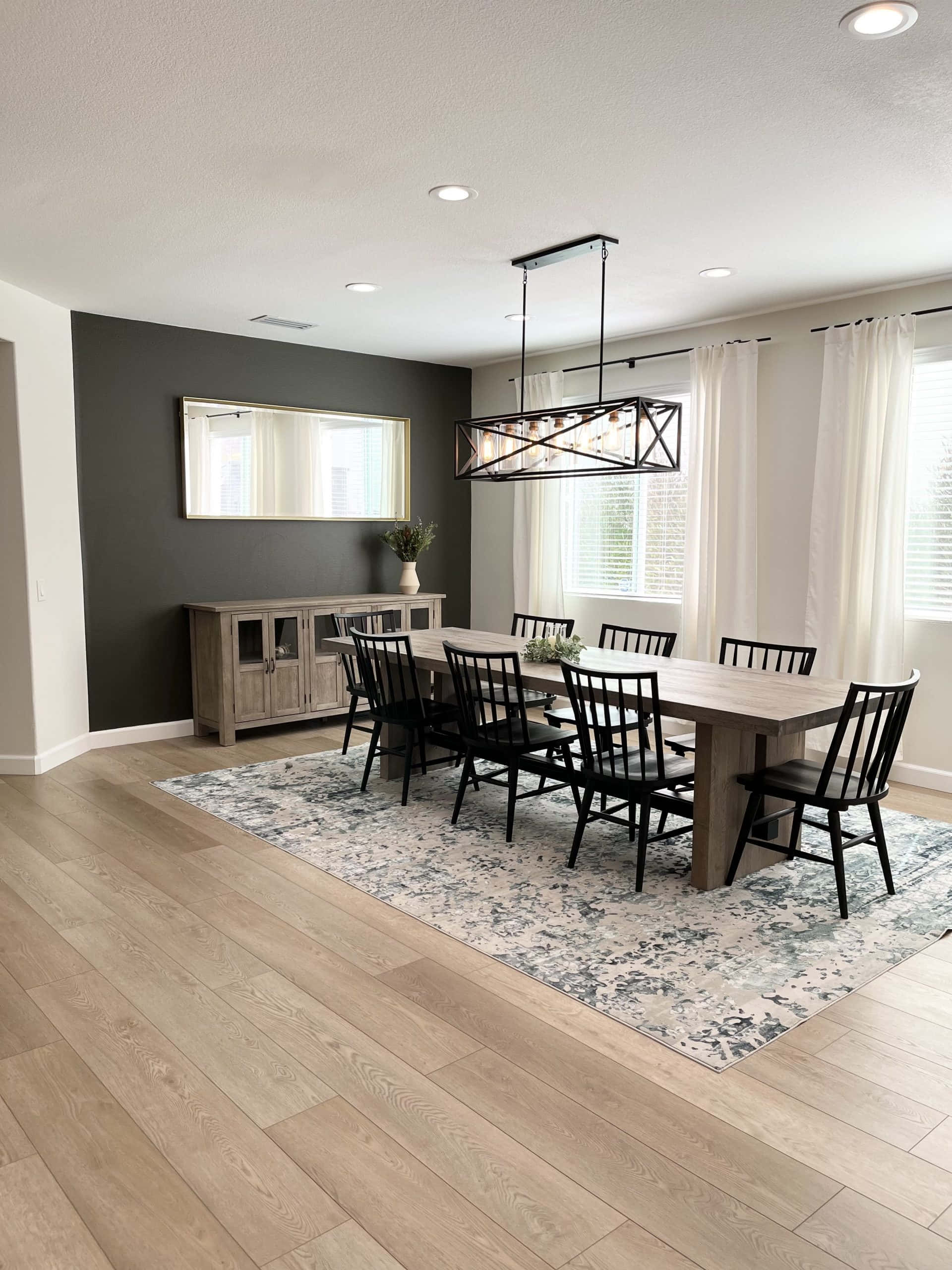 Wood Flooring 桌布 壁紙 — 現代飯廳，配有木桌、黑色椅子、灰色特色牆和帶薄紗窗簾的大窗戶。