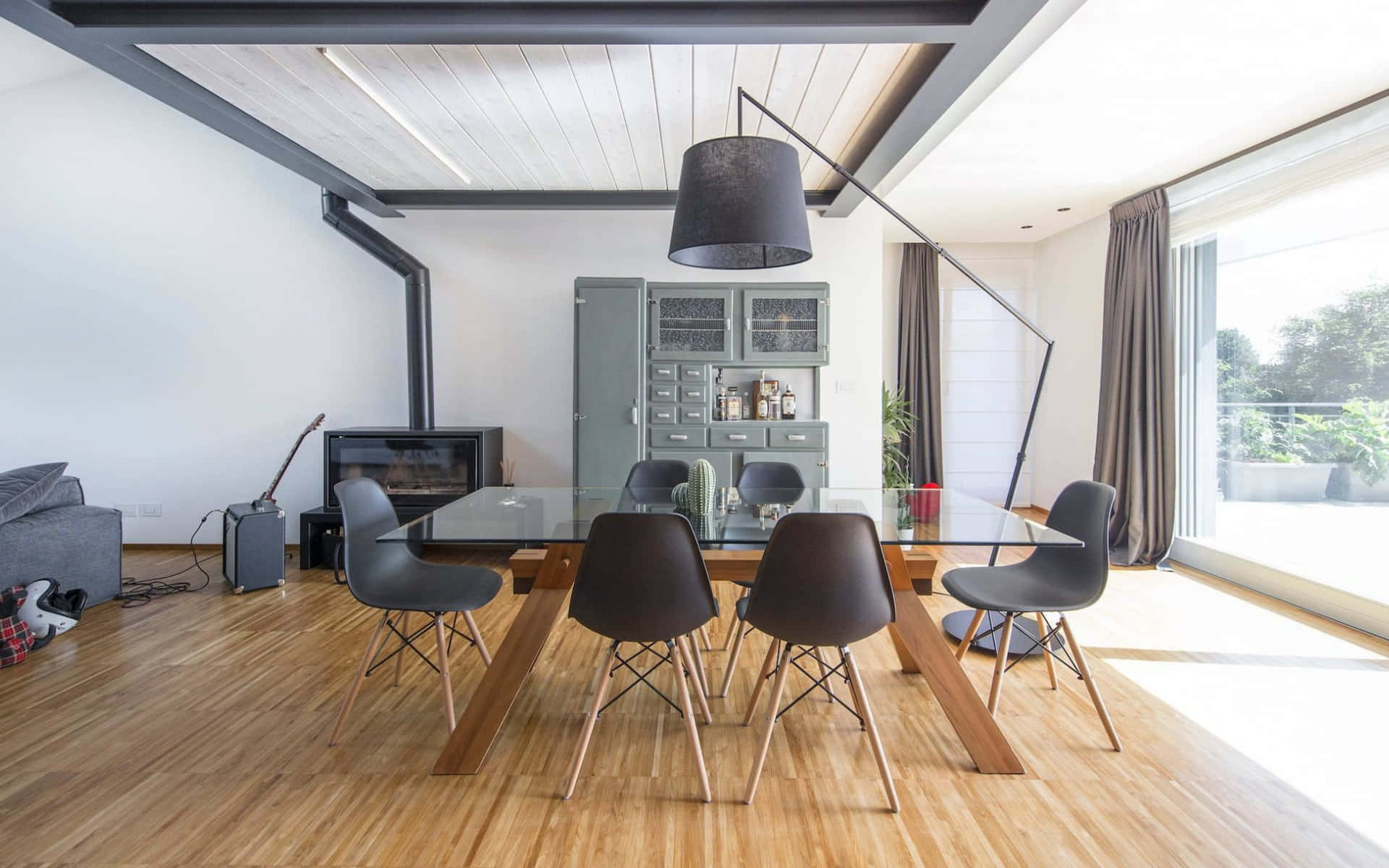 Dining Room 桌布 壁紙 — 現代飯廳，配有玻璃餐桌、深色椅子、木地板和讓自然光線透入的大窗戶。