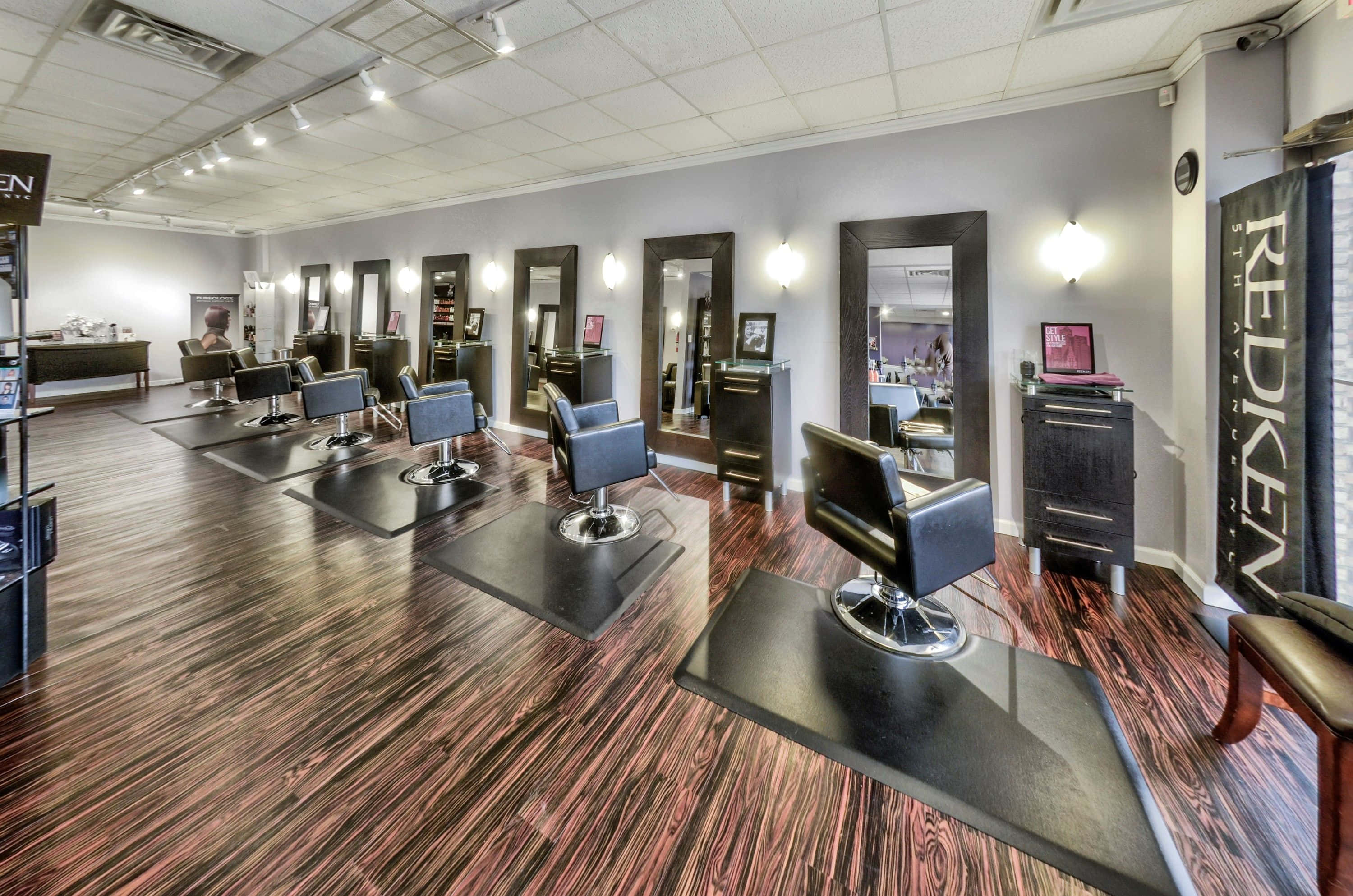 Hair Salon 桌布 壁紙 — 現代髮廊，配有時尚黑色椅子及鏡子，映照出乾淨明亮的空間及木地板。