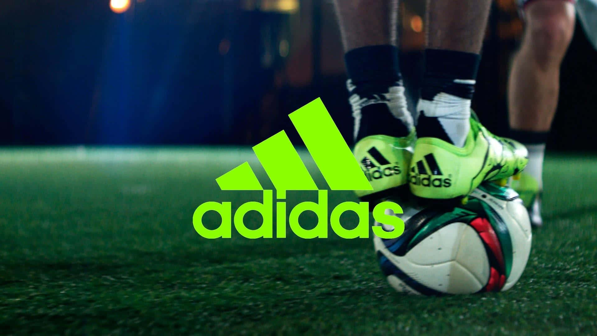 運動 桌布 壁紙 — 球場燈光下，人造草地上足球上的螢光綠色adidas球鞋特寫。