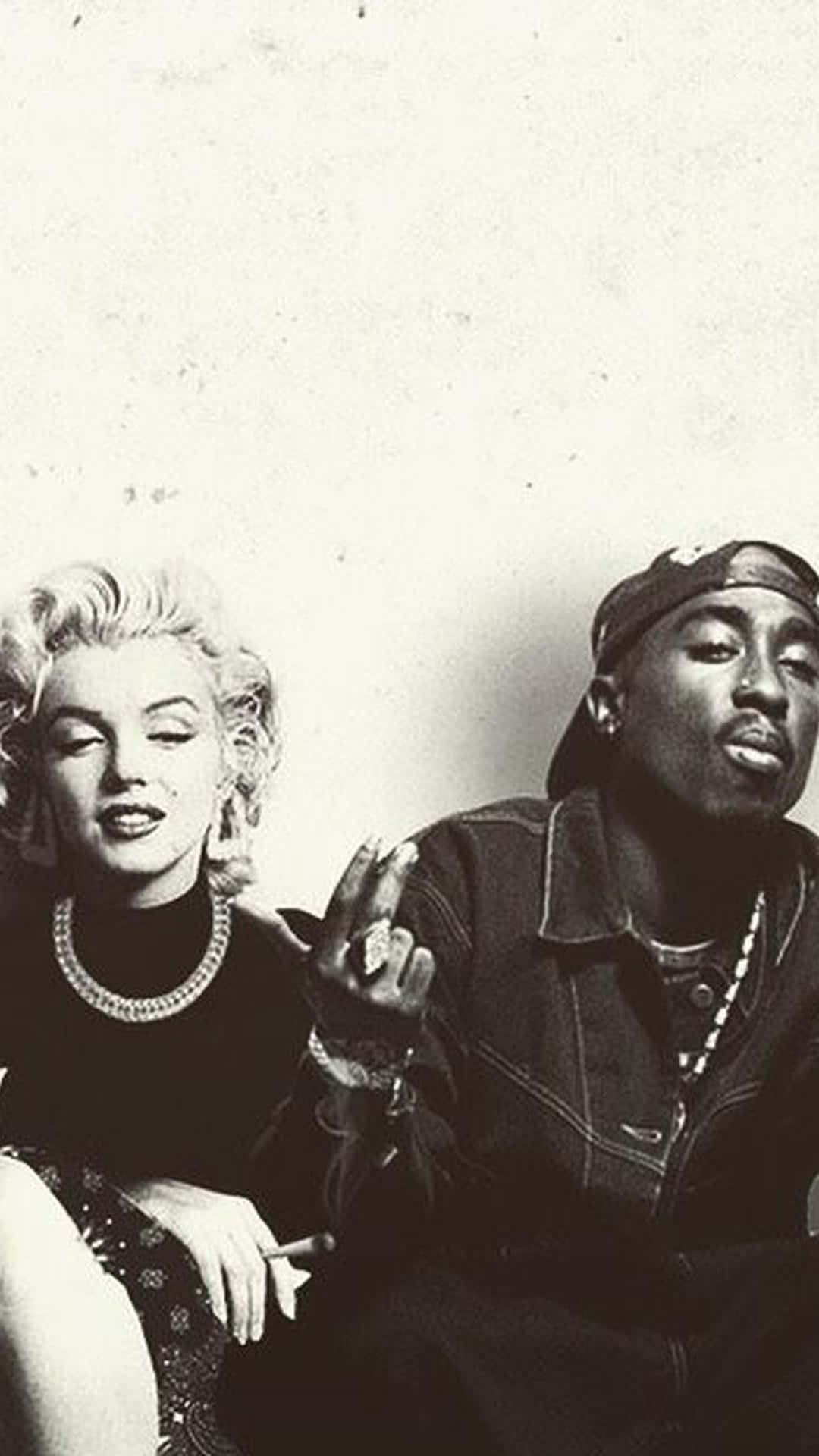 Tupac iPhone 桌布 壁紙 — 瑪麗蓮夢露與圖帕克沙庫爾並排坐在一張復古黑白照片中，兩人都以自信的表情看著鏡頭。