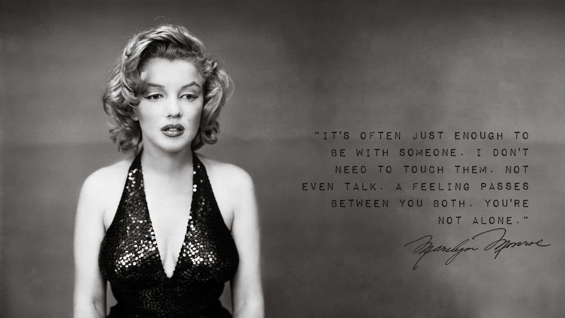 Marilyn Monroe Quotes 桌布 壁紙 — 瑪麗蓮夢露身穿閃亮黑色連衣裙，在柔和的灰色背景上，溫柔地凝視著她手寫的名言。