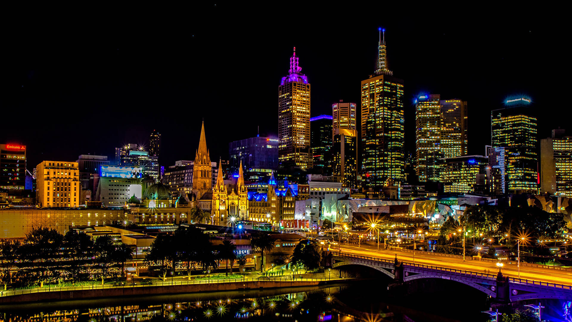 Melbourne 桌布 壁紙 — 璀璨的夜景城市景觀，摩天大樓和歷史建築的燈光倒映在下面的河流中。