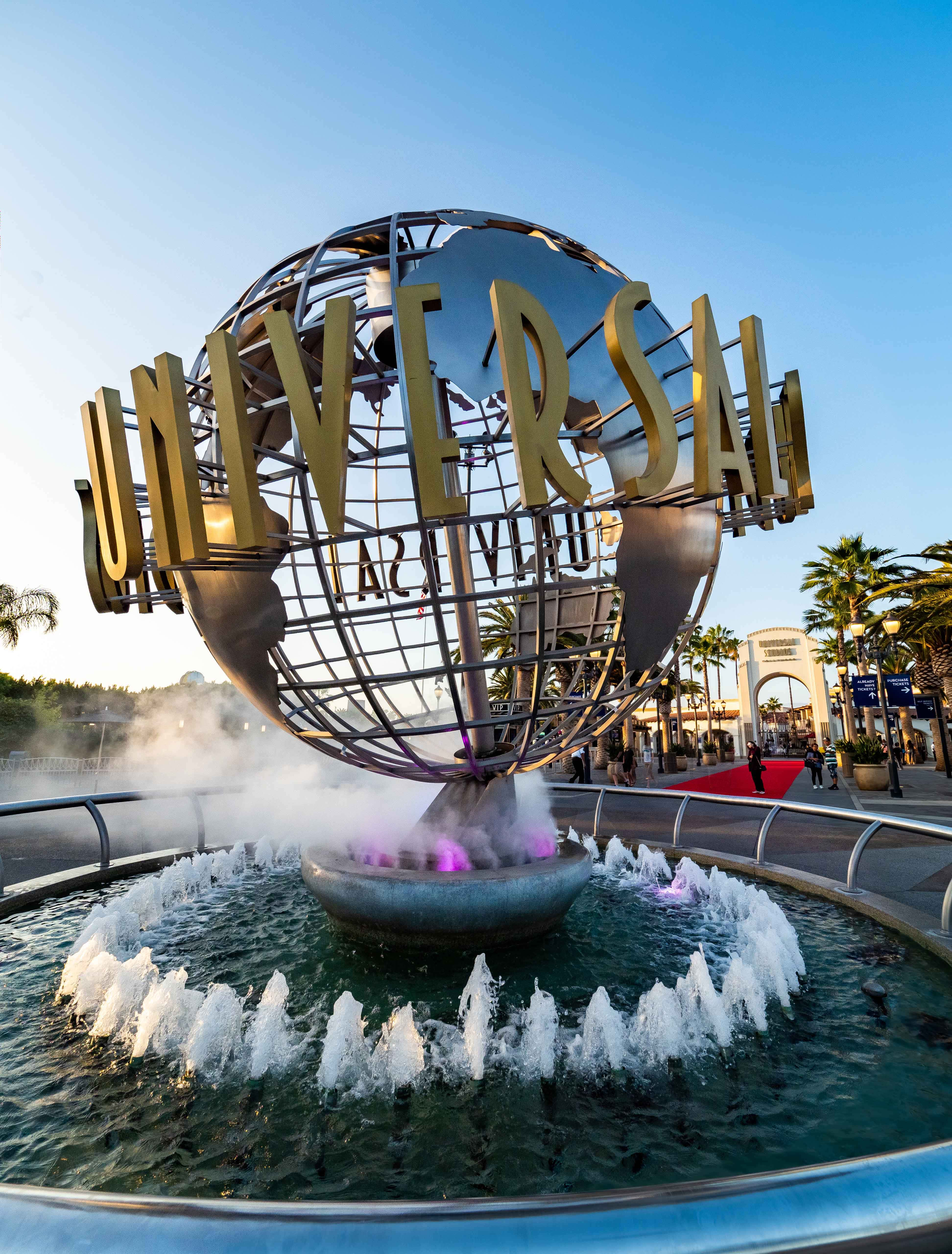 Universal 桌布 壁紙 — 環球影城標誌性的地球儀地標在金色夕陽下閃閃發光，噴泉底座升起薄霧。