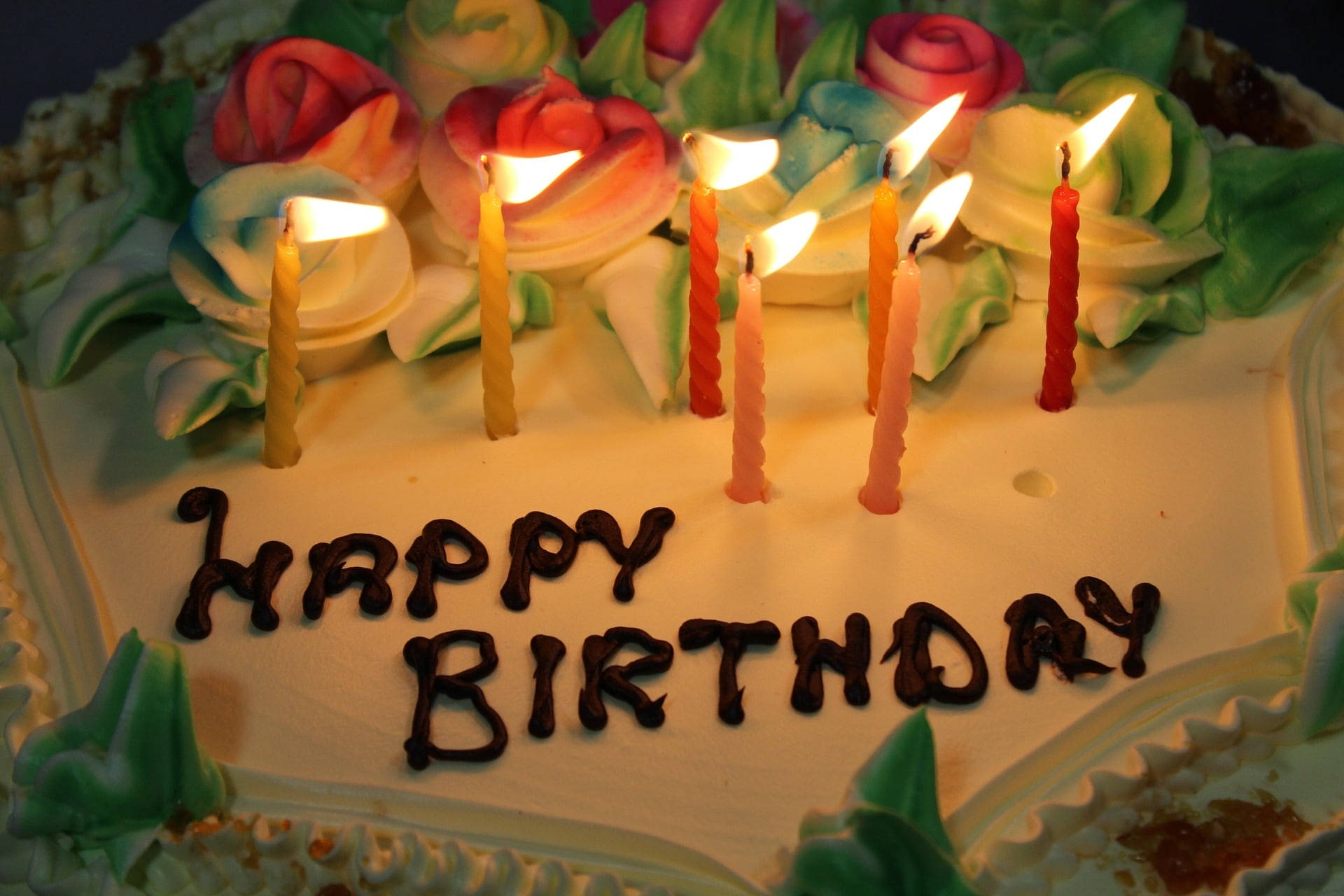 Happy Birthday Flower 桌布 壁紙 — 生日蛋糕特寫，有燃點蠟燭和巧克力字拼出happy birthday。
