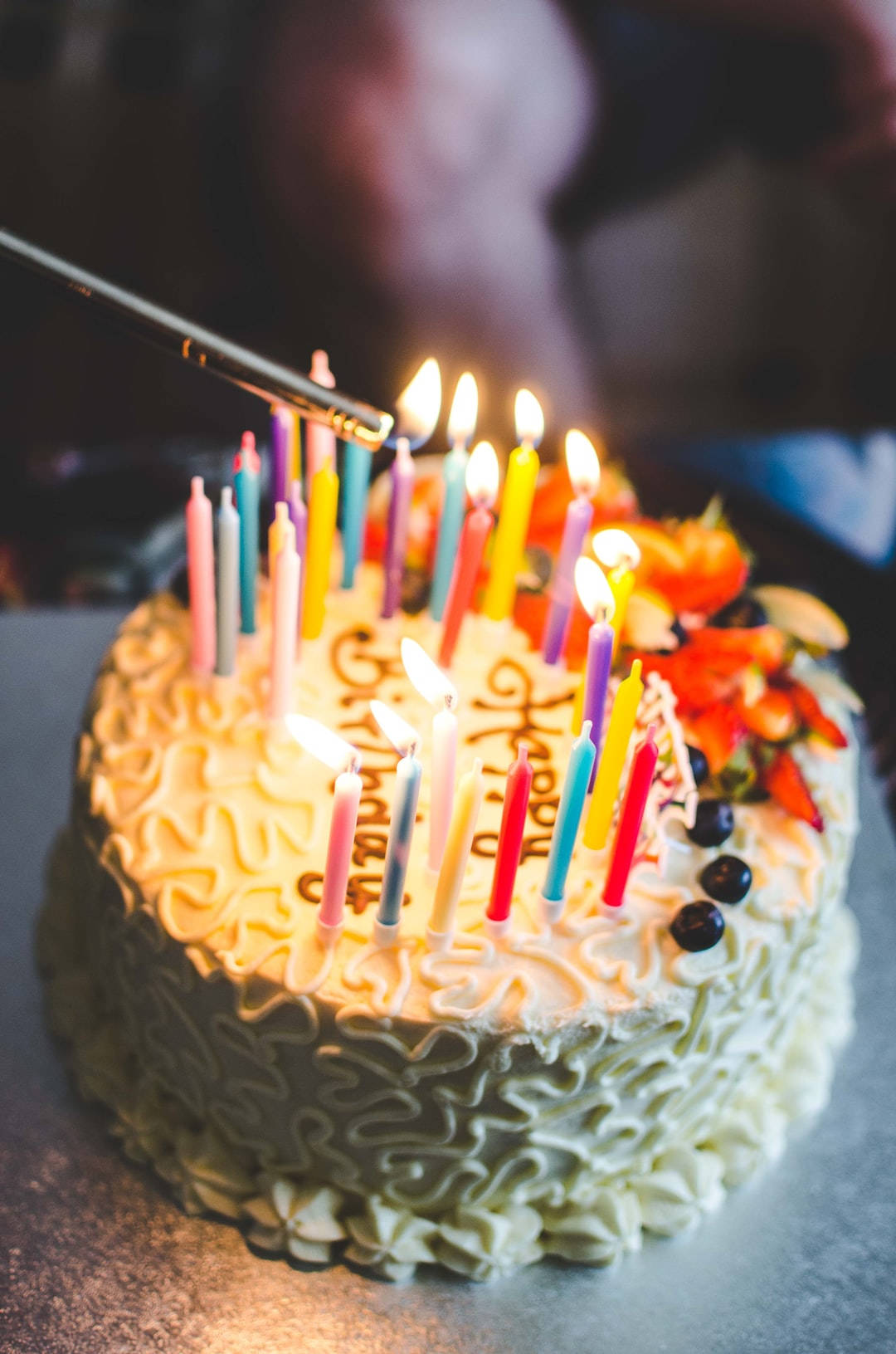 蛋糕 桌布 壁紙 — 生日蛋糕的特寫，上面有燃燒的彩色蠟燭和新鮮水果配料。