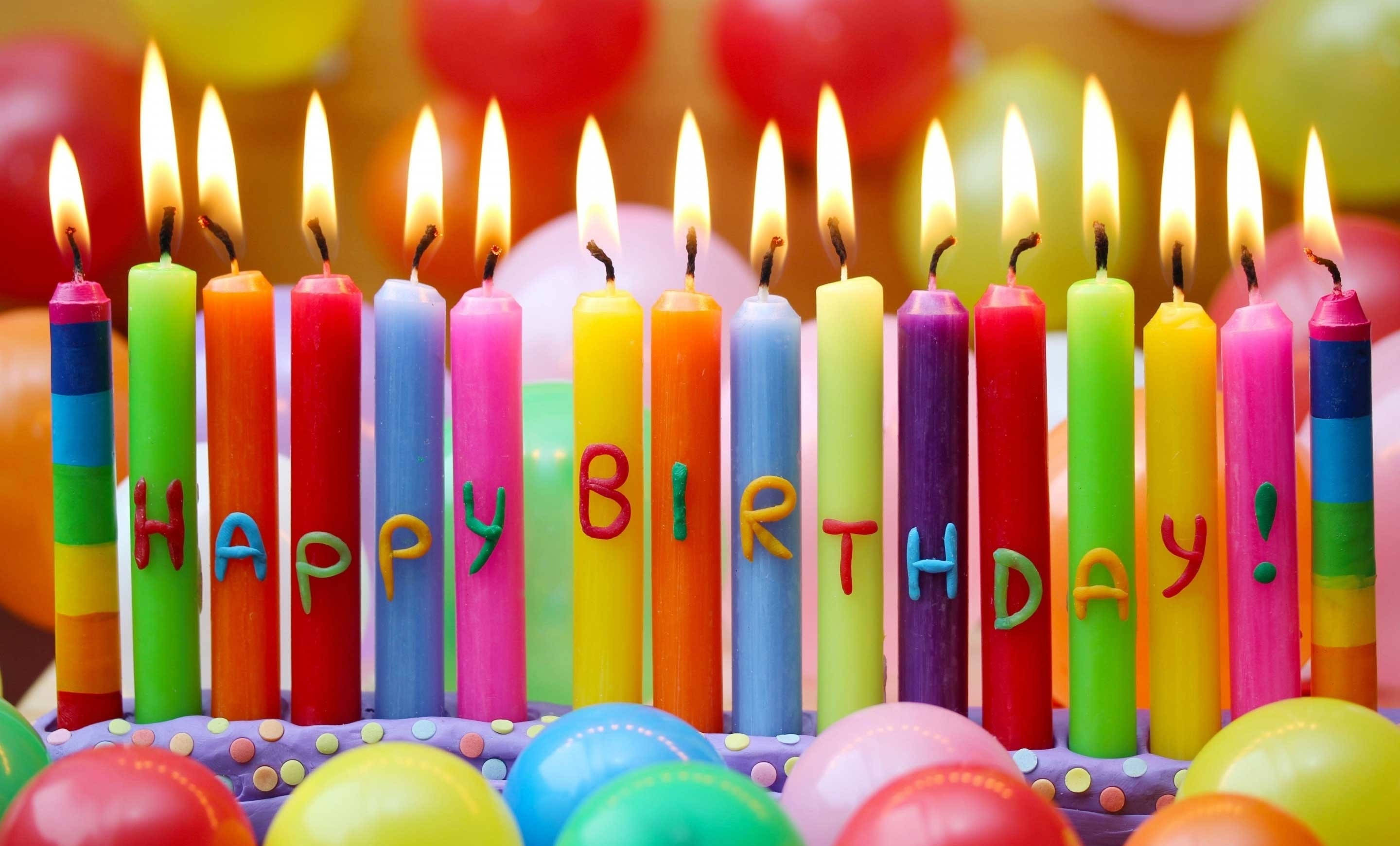 Cake 桌布 壁紙 — 生日蛋糕的特寫，彩色蠟燭拼出「HAPPY BIRTHDAY」，點燃的火焰被氣球環繞。