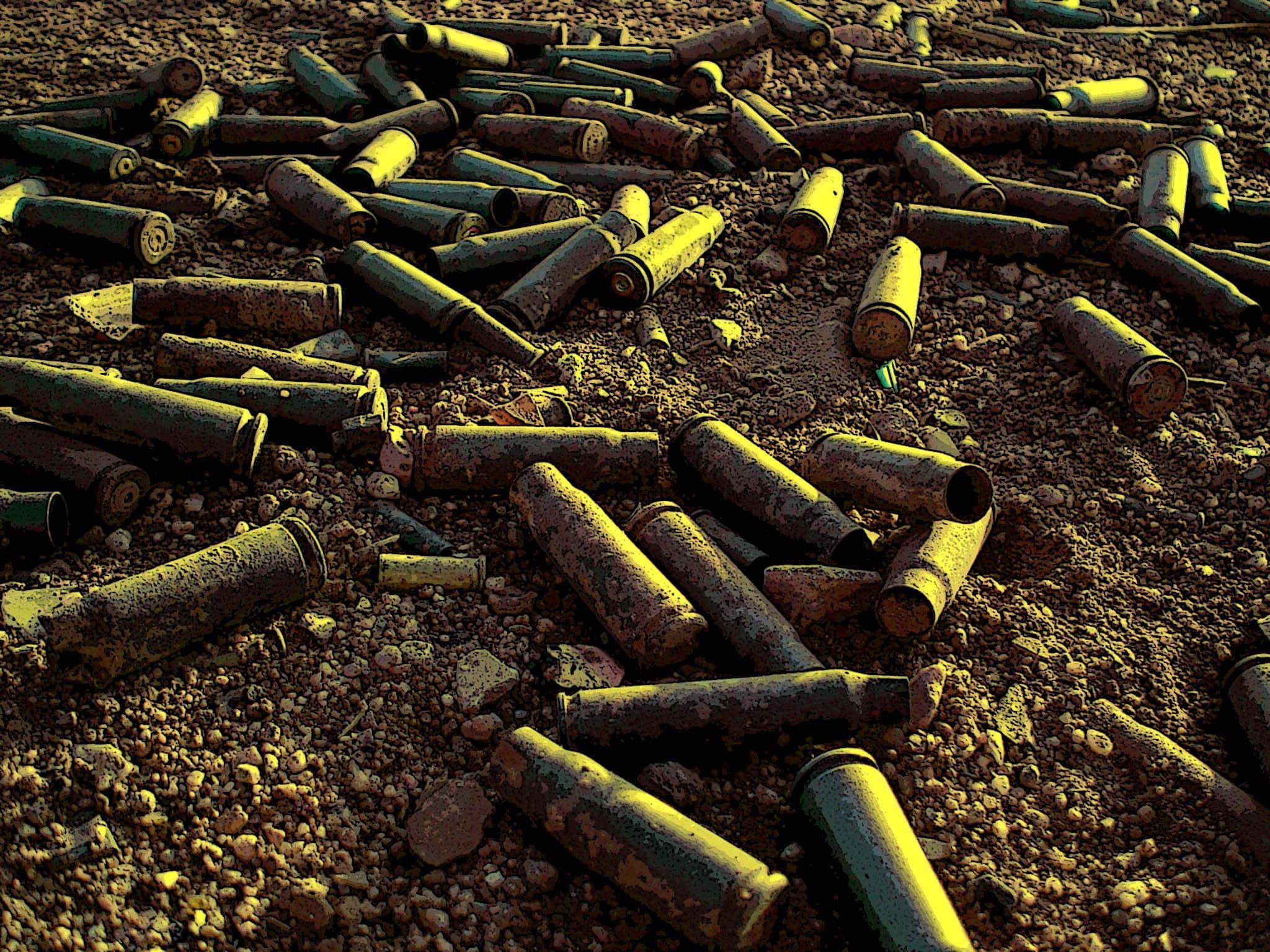 bullet 桌布 壁紙 — 生鏽的子彈殼散落在粗糙的沙漠地面上，沐浴在溫暖的金色光線中。