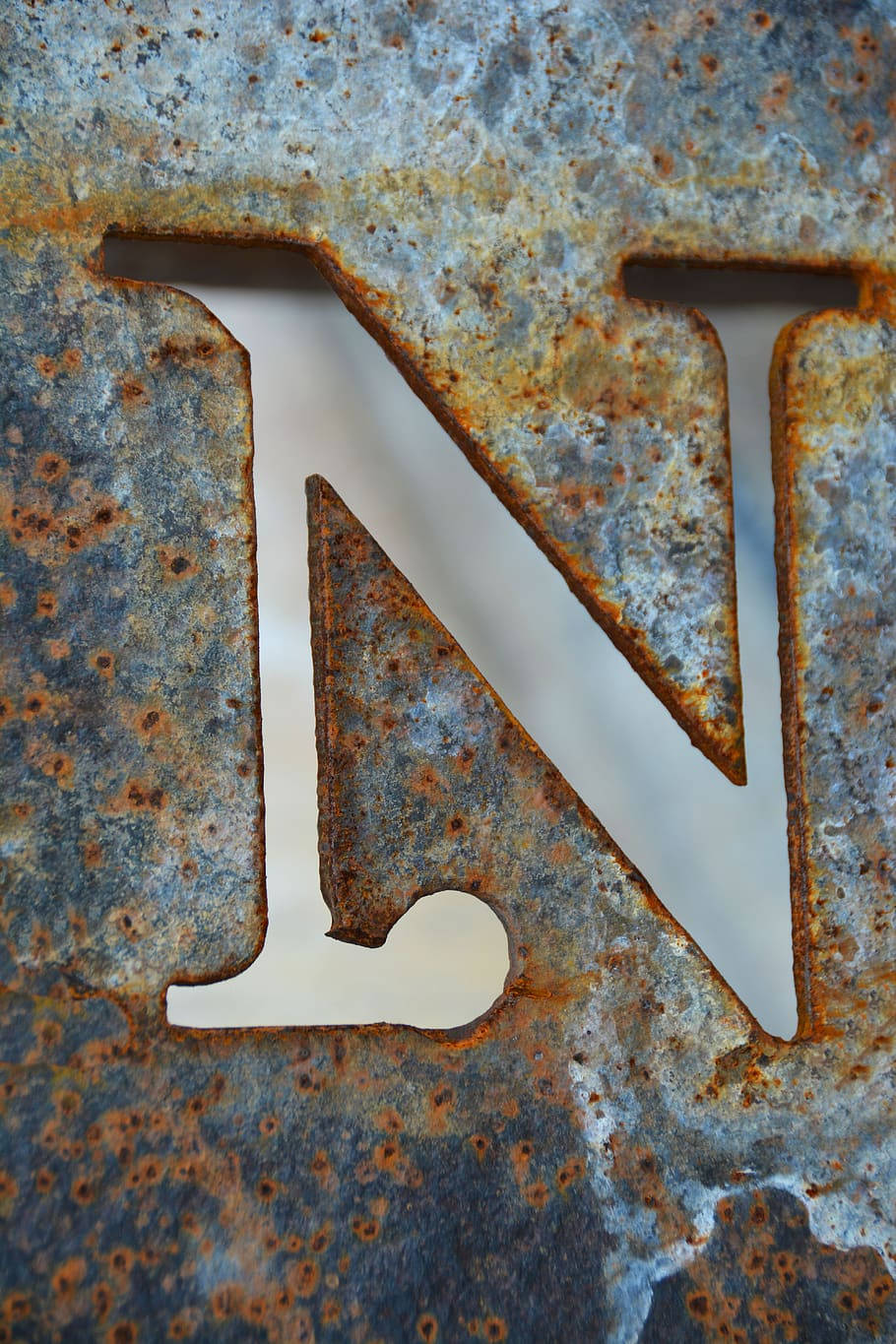 字母 N 桌布 壁紙 — 生鏽金屬字母N的特寫，帶有紋理銅綠和風化邊緣。