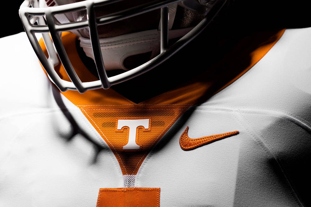 University Of Tennessee 桌布 壁紙 — 田納西州足球運動員頭盔和球衣的特寫，帶有醒目的橙色和白色細節。