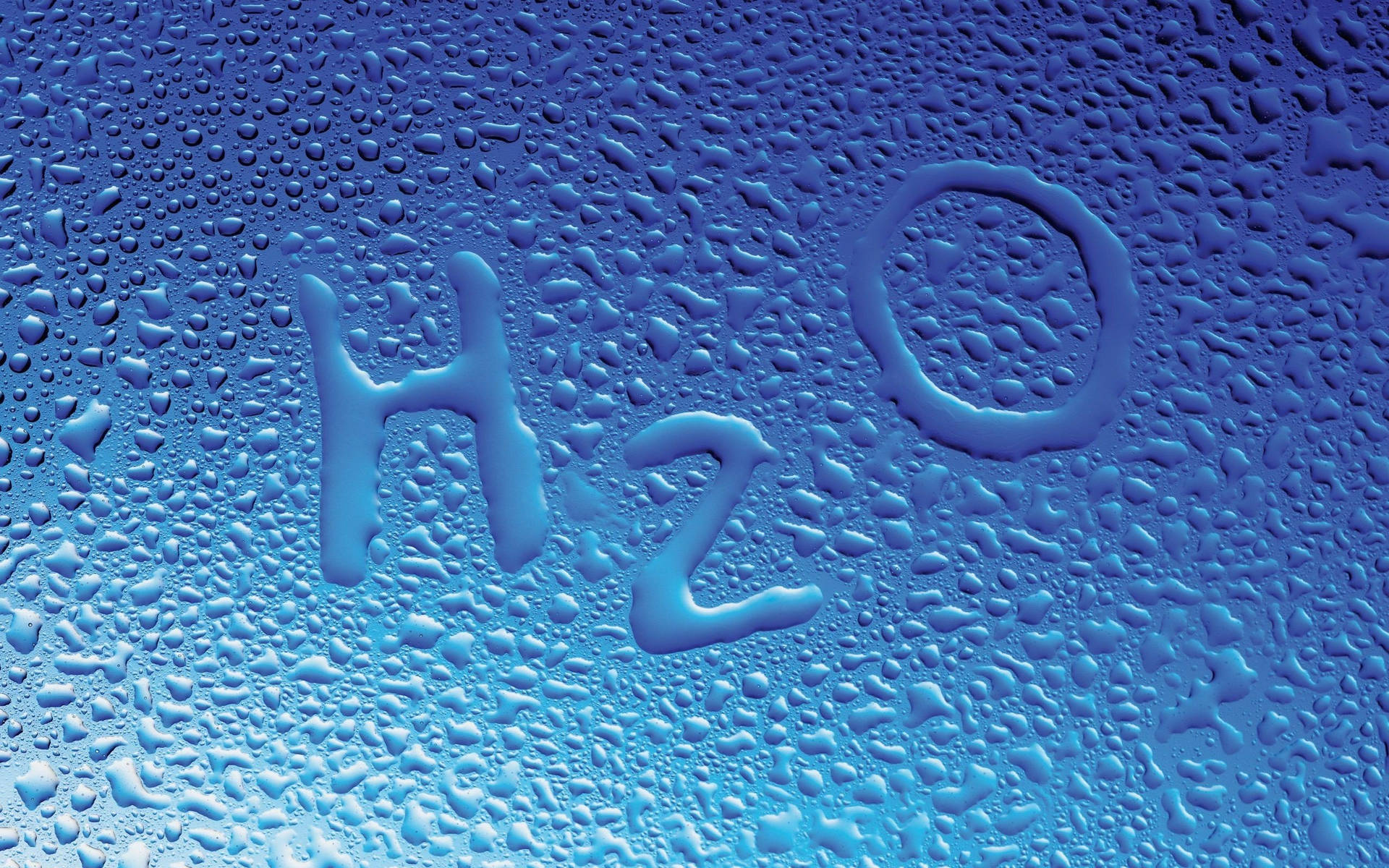 水滴在藍色表面上拼出 H2O。 — 化學 GIF 壁紙