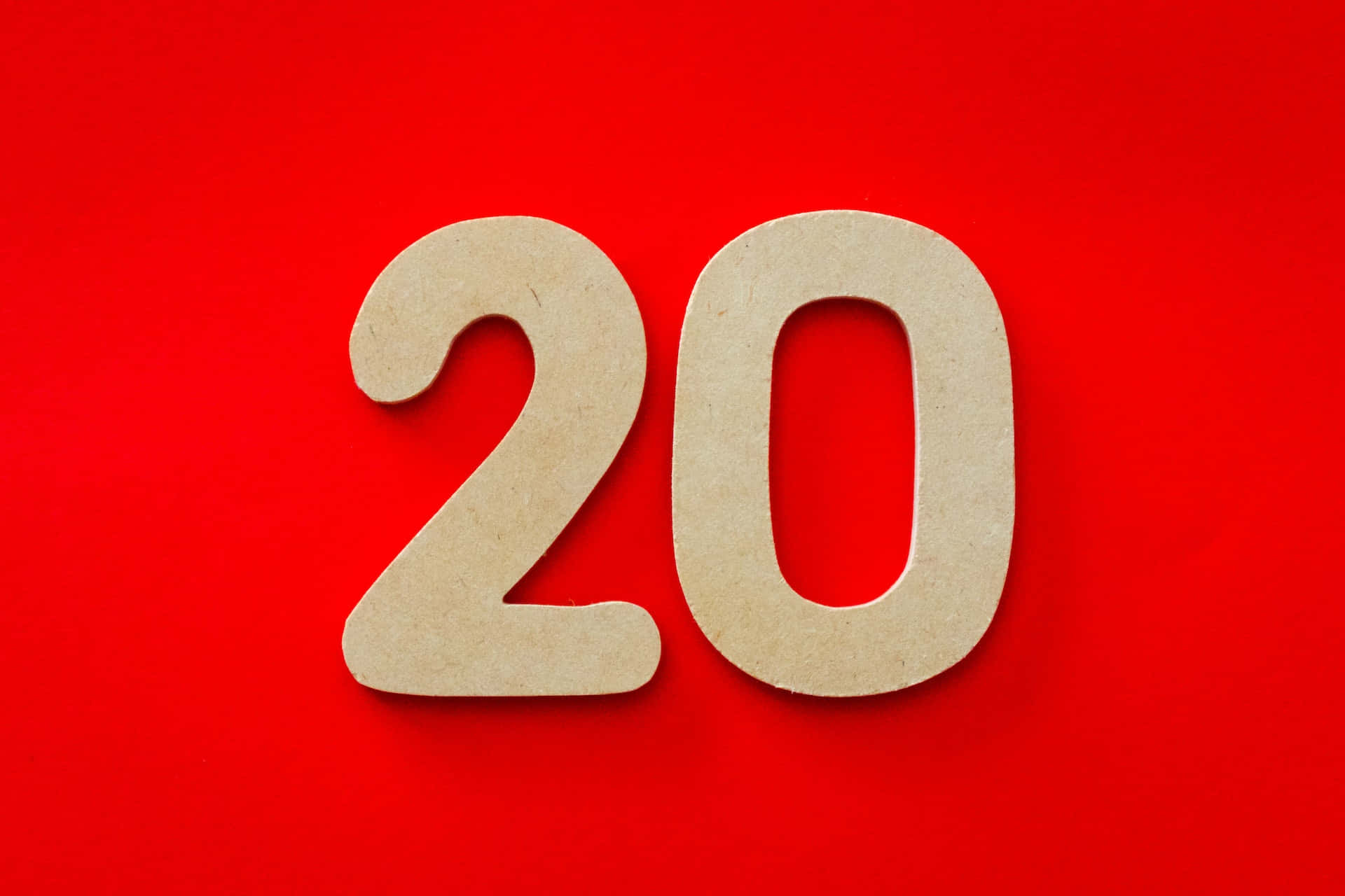 Number 桌布 壁紙 — 由淺色木材製成的數字二十在鮮紅色背景上大膽地矗立。