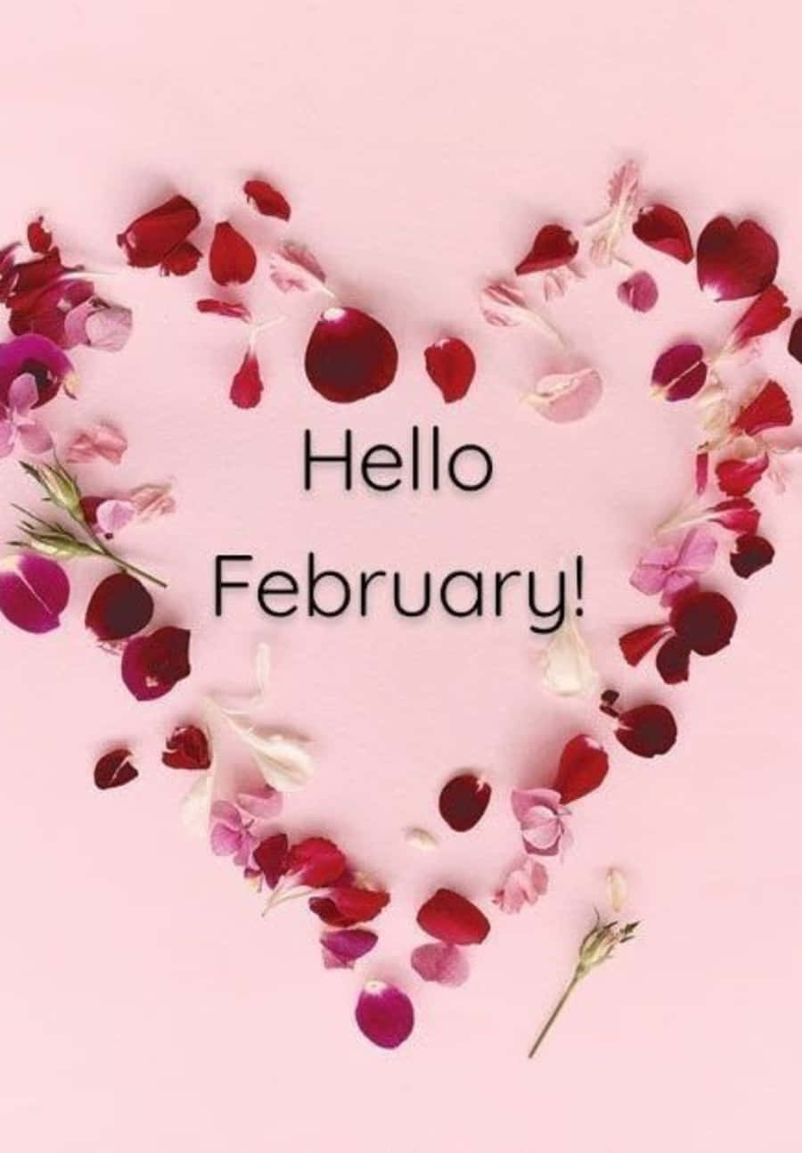 February iPhone 桌布 壁紙 — 由紅色和粉紅色玫瑰花瓣組成的愛心，置於柔和粉紅色背景上，並帶有文字「你好二月！」