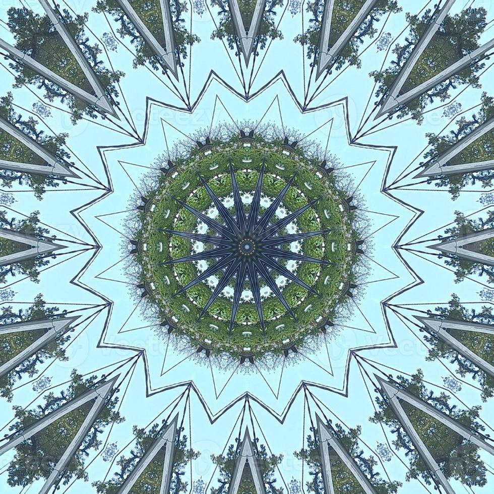 Aesthetic Trippy 桌布 壁紙 — 由鏡像樹木和天空組成的萬花筒曼陀羅，形成對稱的星形圖案，帶有綠色樹葉和淺藍色天空。
