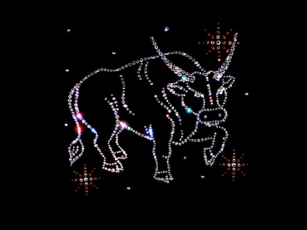taurus 桌布 壁紙 — 由閃亮水鑽形成的閃爍公牛剪影，背景為黑色，並散落著色彩繽紛的星爆。
