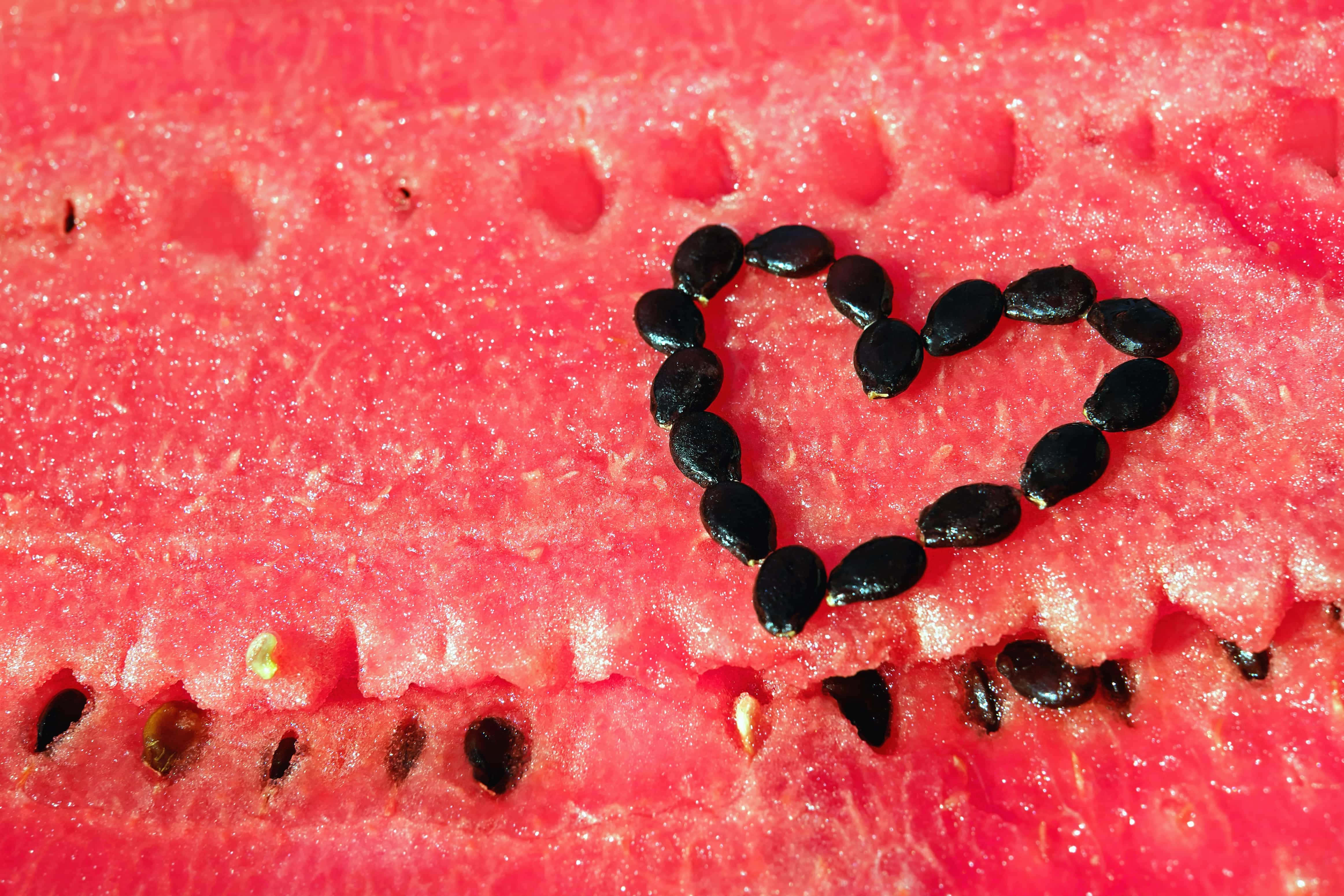 Fruit 桌布 壁紙 — 由黑色西瓜籽在鮮紅多汁的果肉上形成的愛心形狀。