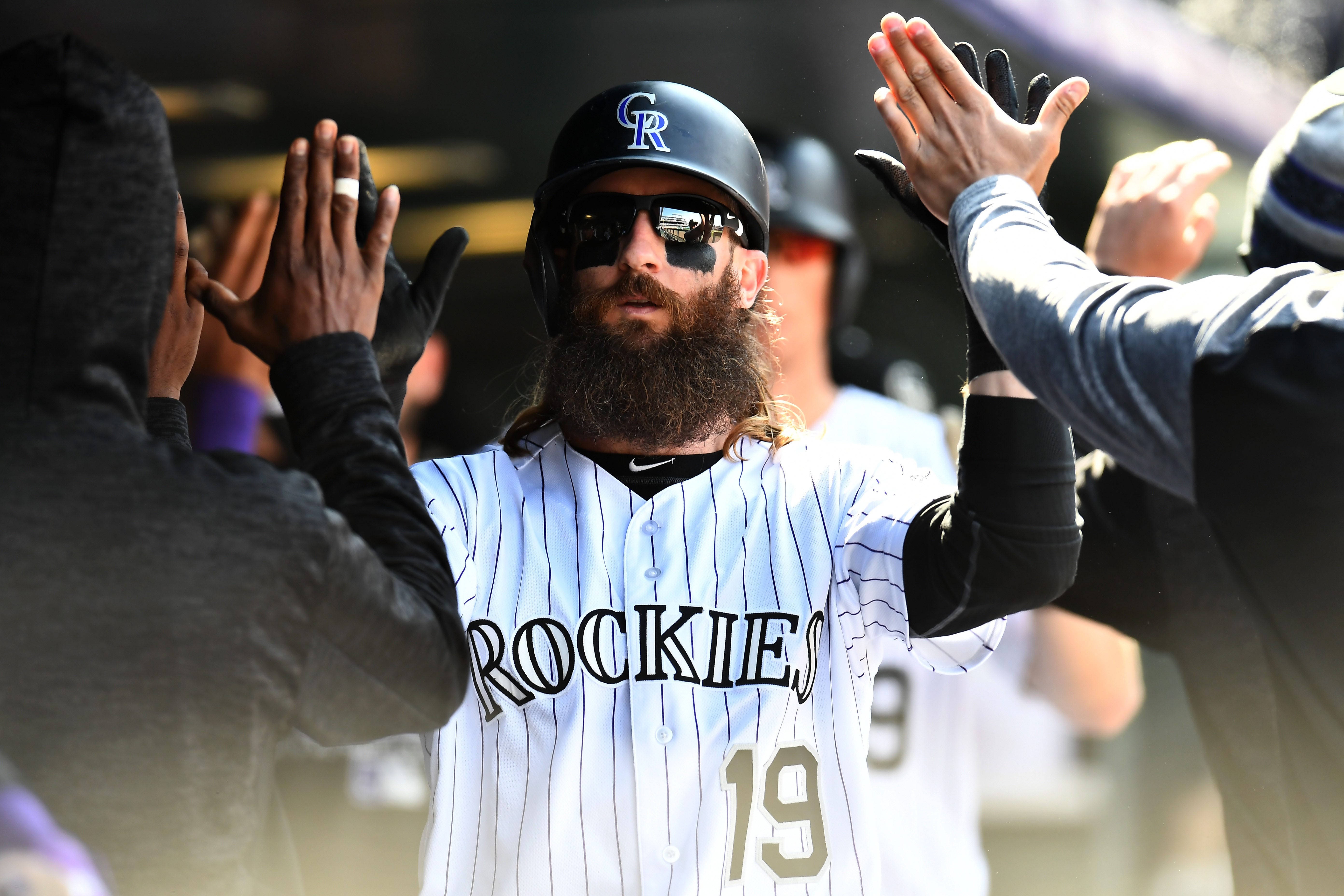 baseball bat 桌布 壁紙 — 留鬍子的棒球運動員穿著洛磯隊制服，在明亮的日光下與休息區的隊友擊掌。