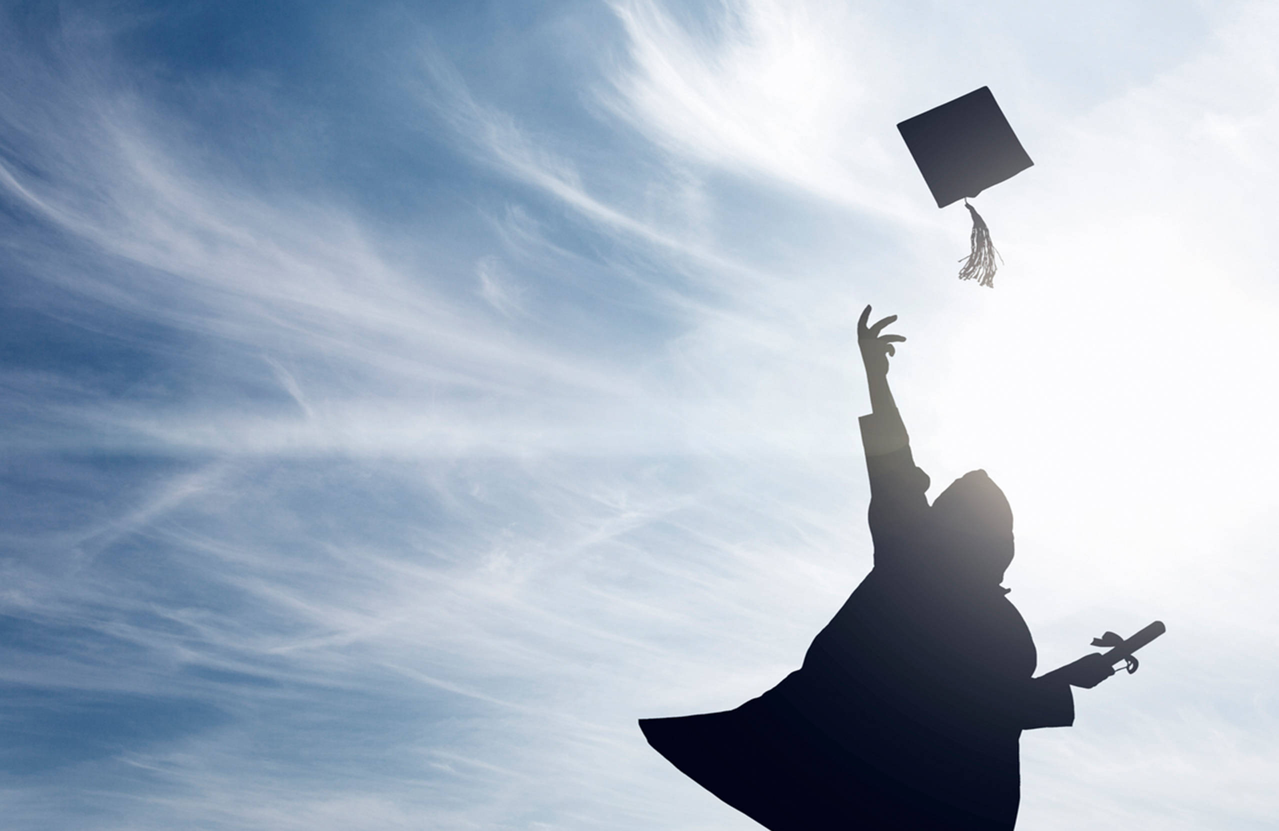 Graduation 桌布 壁紙 — 畢業生將學士帽拋向藍天白雲的剪影。