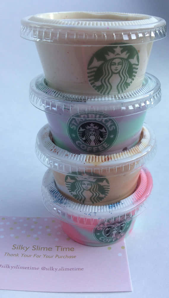 slime 桌布 壁紙 — 疊起的Starbucks星冰樂杯子，帶有彩色漩渦和亮粉，放在粉紅色圓點卡上。
