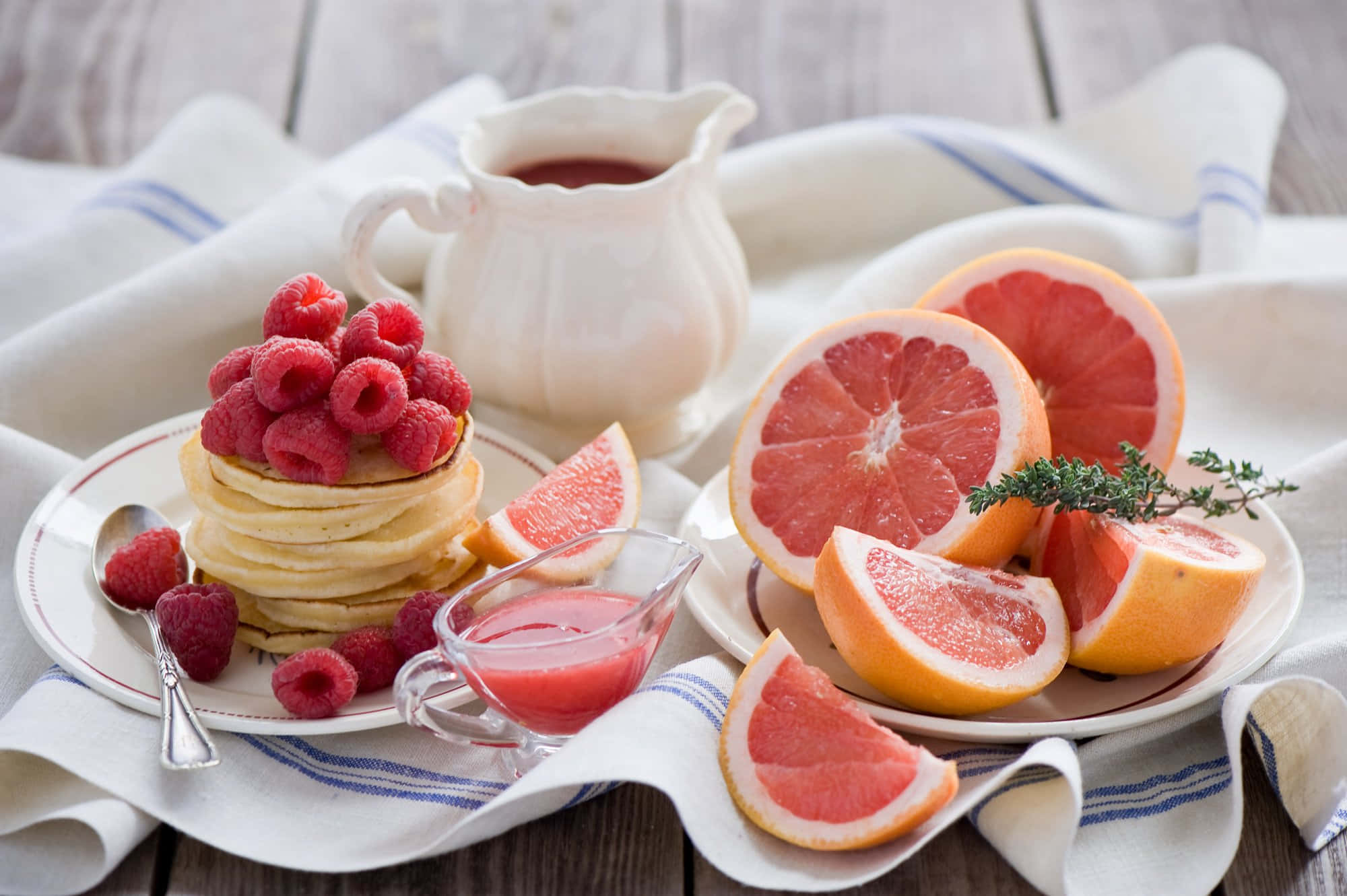 Fruits 桌布 壁紙 — 疊起的煎餅，上面放上新鮮覆盆子和切片葡萄柚，放在質樸的木桌上，附有一壺糖漿。