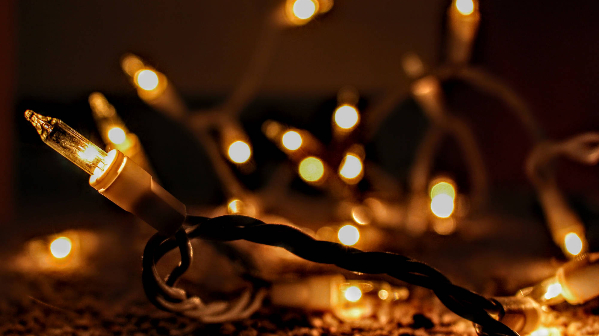 Christmas Lights Aesthetic 桌布 壁紙 — 發光燈串的特寫，帶有溫暖的散景背景，營造舒適氛圍。