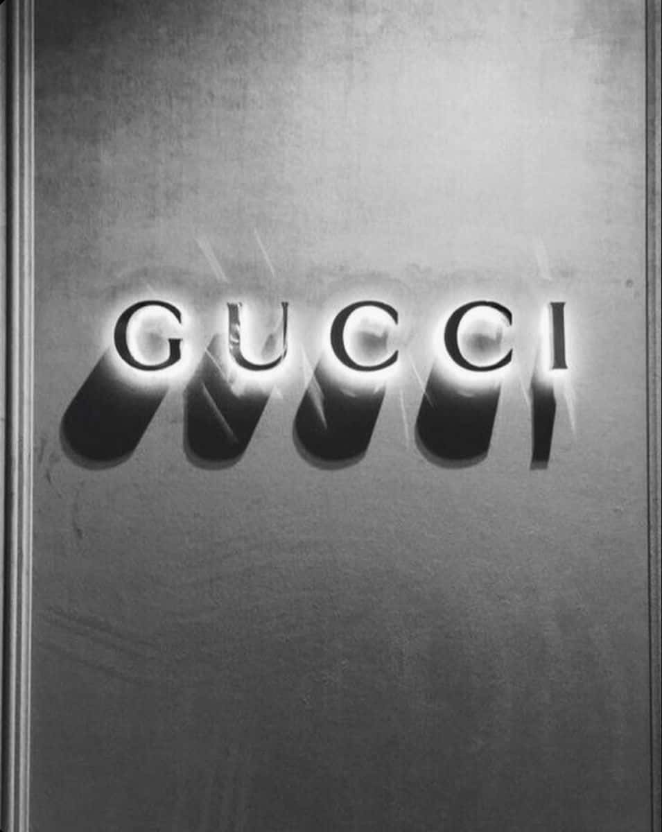 Gucci 標誌在帶有紋理的金屬背景上發光。 — Gucci GIF 壁紙