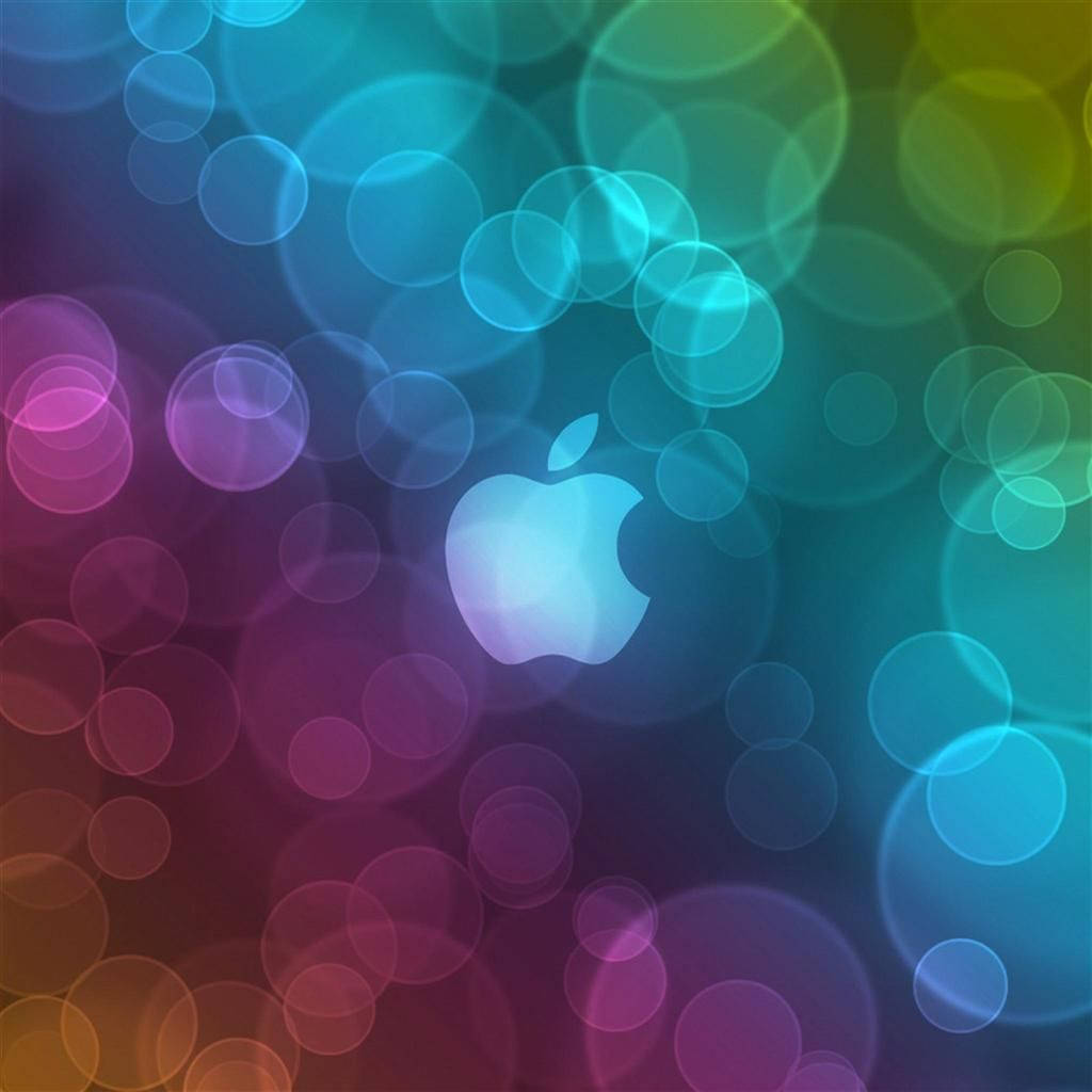 Apple標誌被色彩繽紛的發光圓圈包圍，背景為漸變色。 — iPad mini 動態圖片 壁紙