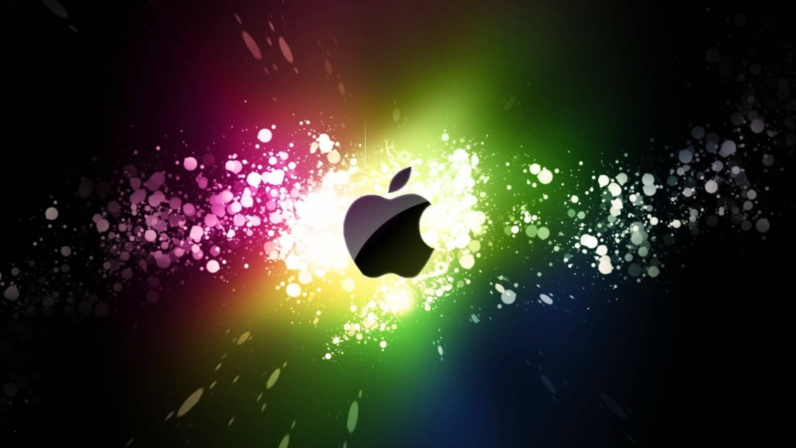 Spectrum 桌布 壁紙 — 發光的Apple標誌在深色背景上散發出鮮豔的彩虹粒子。