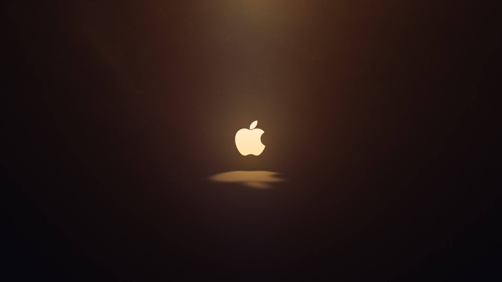 發光的Apple標誌在黑暗空間中置中，帶有柔和光線。 — 蘋果標誌 GIF 壁紙