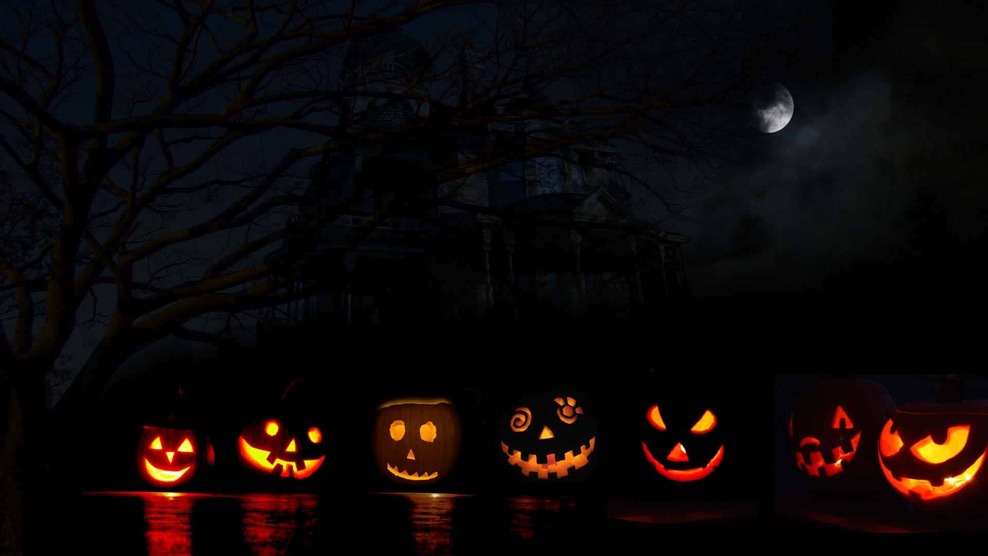 Halloween Pumpkin 桌布 壁紙 — 發光的傑克南瓜燈漂浮在水面上，背景是新月和黑暗中的鬼屋。