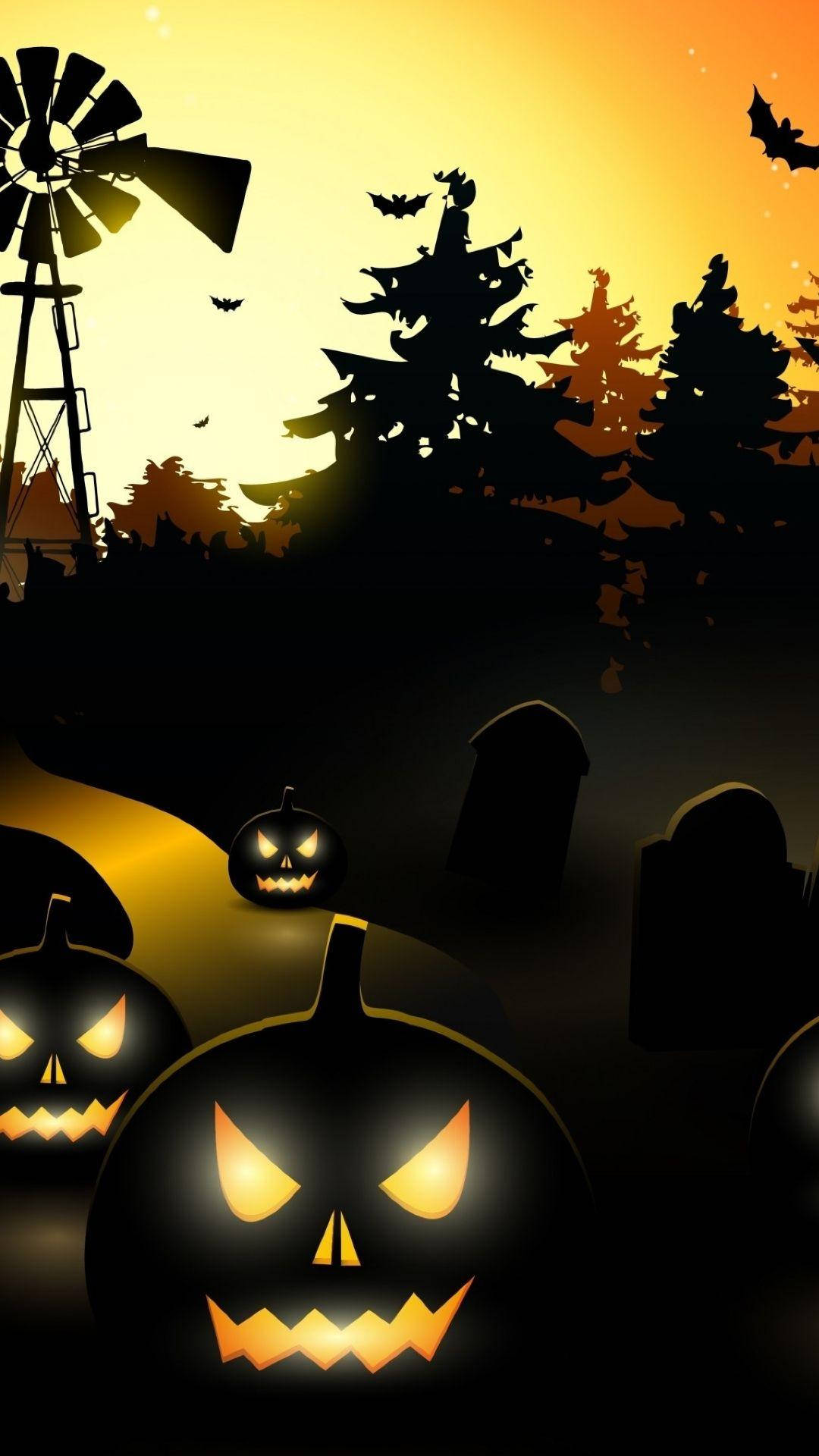 Haunted House Halloween 桌布 壁紙 — 發光的傑克南瓜燈照亮了暮色中陰森的墓地，有樹木、風車和飛翔蝙蝠的剪影，背景是橙色天空。