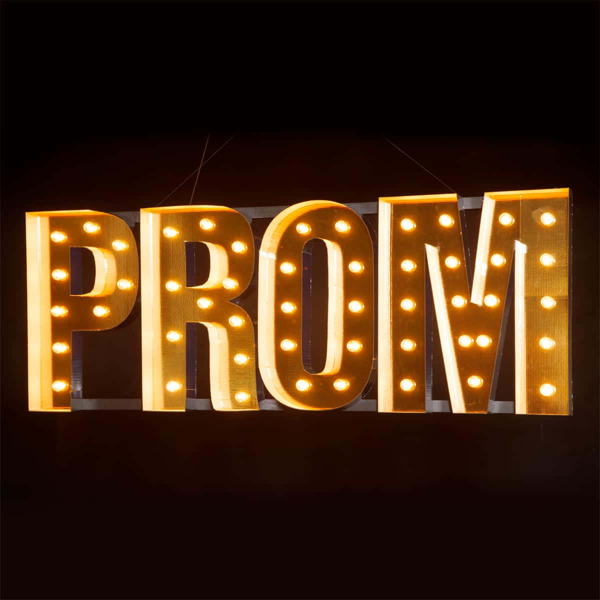 Party 桌布 壁紙 — 發光的帳篷字母拼出PROM，由溫暖的燈泡照亮，背景為深色。