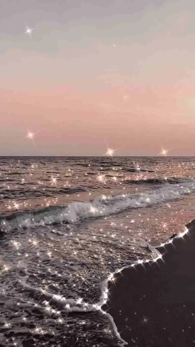 夏天 桌布 壁紙 — 發光的海浪在海岸線閃爍著星光，映襯著柔和的粉紅色暮色天空。