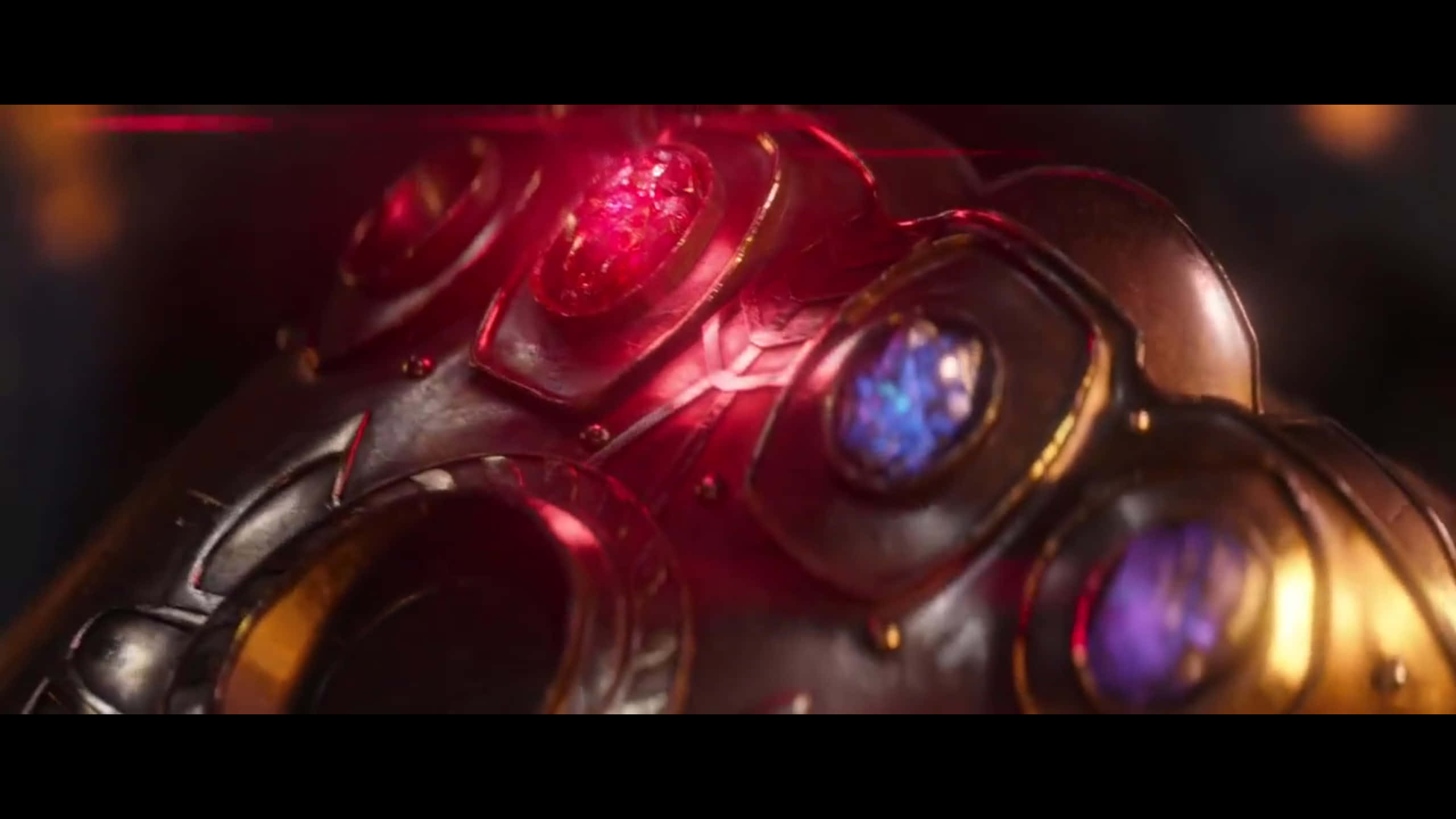 Reality Stone 桌布 壁紙 — 發光的無限手套特寫，紅色和藍色寶石在黑暗背景上脈動。