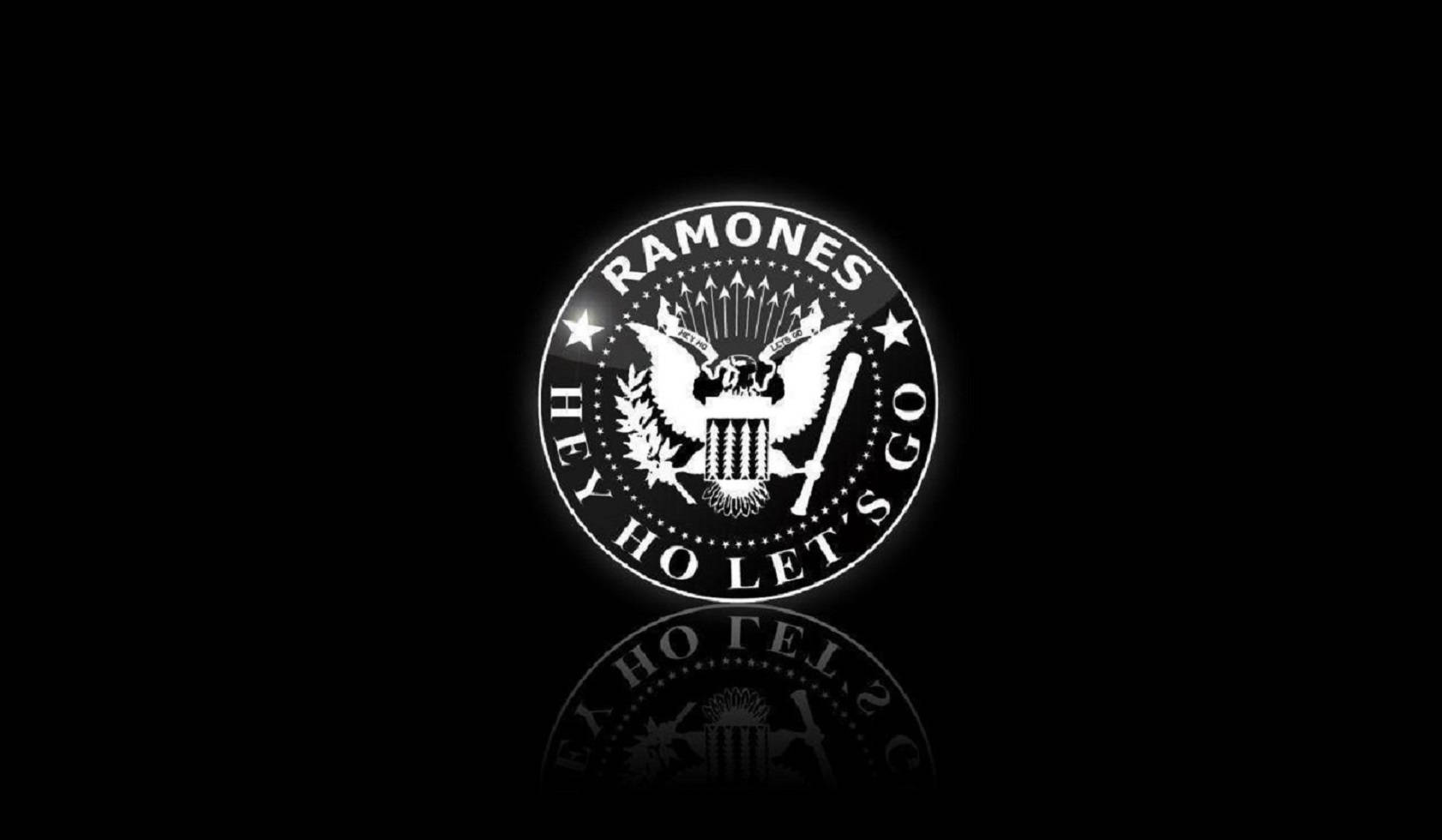 Eagle 桌布 壁紙 — 發光的白色 Ramones 標誌，帶有鷹和星星，在黑色背景上發出光芒，帶有微妙的倒影。
