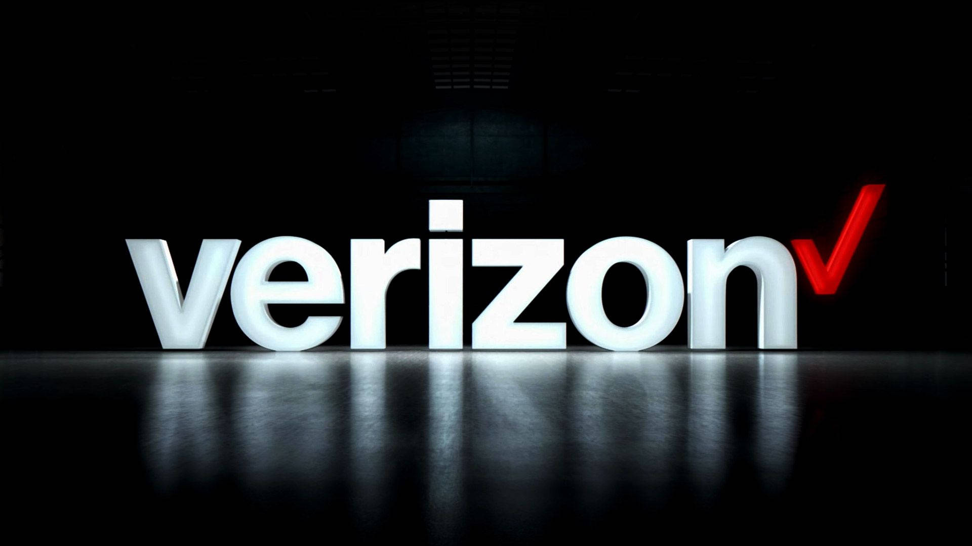 Verizon 桌布 壁紙 — 發光的白色和紅色Verizon標誌字母立在黑暗工作室環境中的反光黑色地板上。