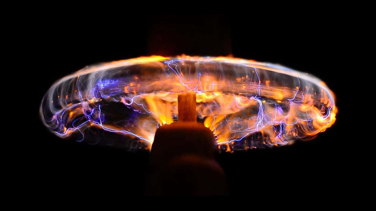 電力 桌布 壁紙 — 發光的等離子球體，帶有鮮豔的藍色和橙色電弧，在黑色背景上圍繞中心桿旋轉。