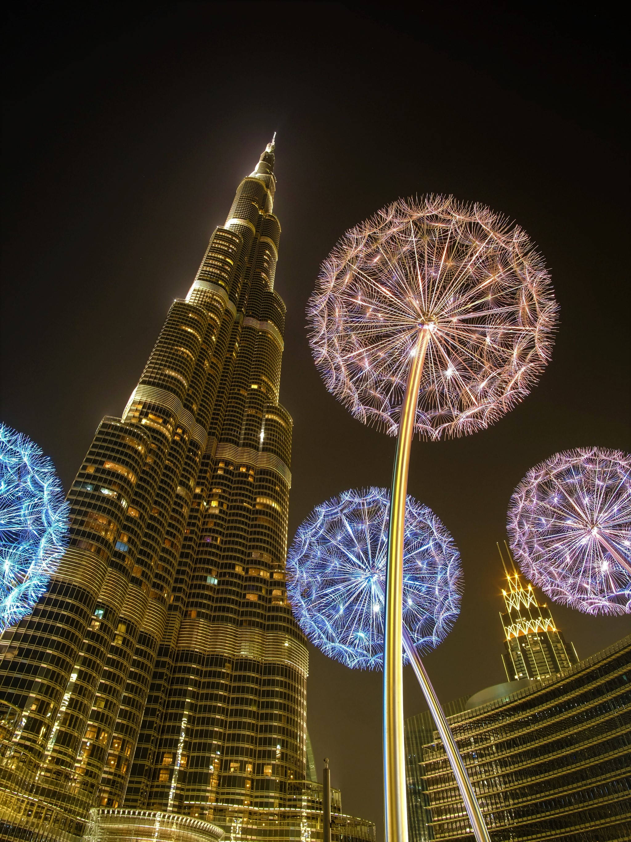 lights 桌布 壁紙 — 發光的蒲公英雕塑在夜間杜拜的哈里發塔襯托下閃耀。