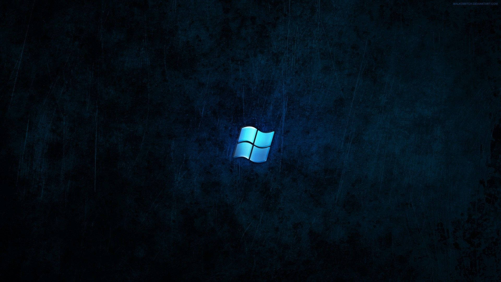 Dark Windows 桌布 壁紙 — 發光的藍色Windows標誌在帶有細微雨紋的深色紋理背景上閃耀。