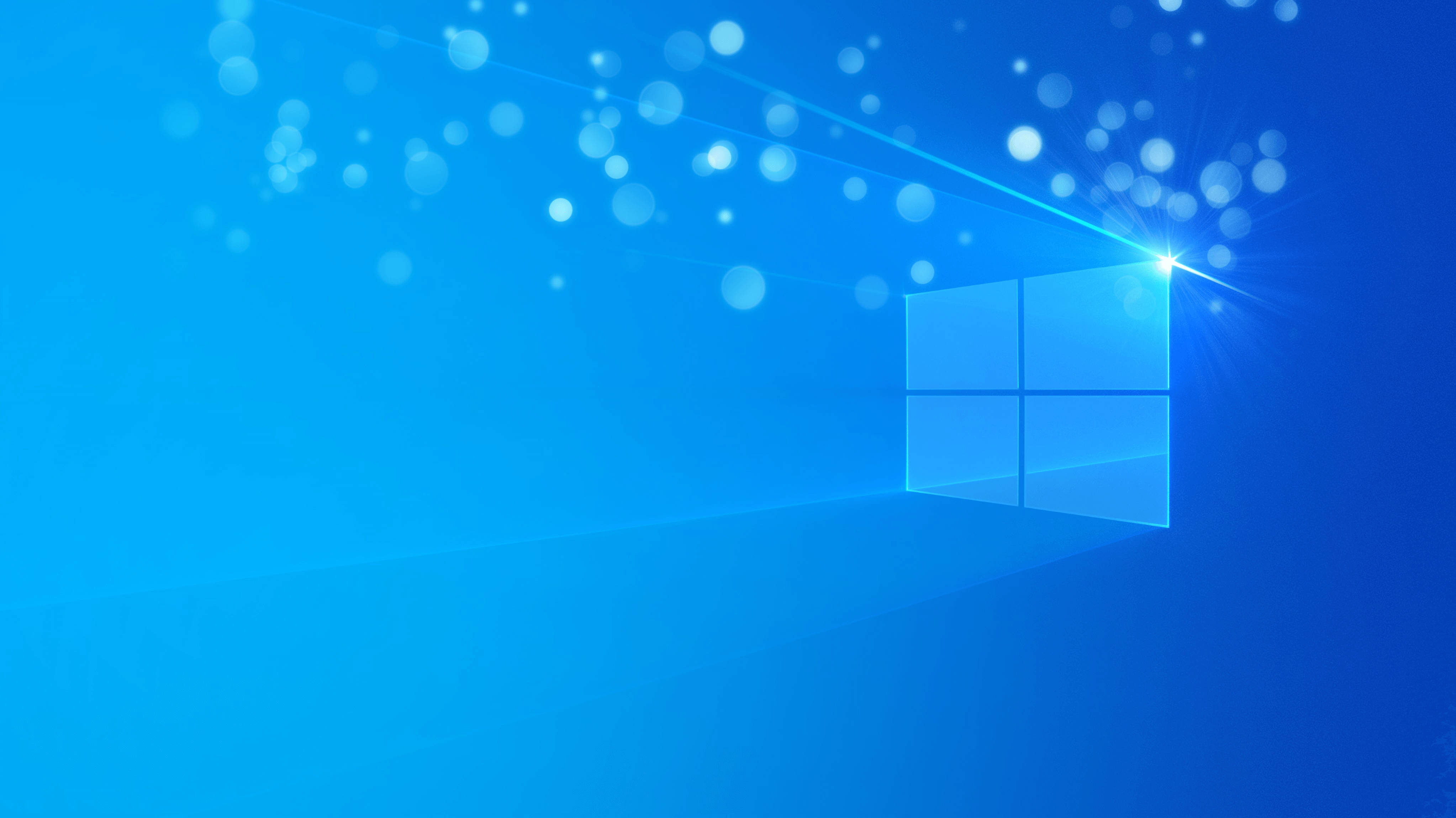 Windows 11 4K 桌布 壁紙 — 發光的藍色Windows標誌在漸變藍色背景上閃耀著光線和散景粒子。