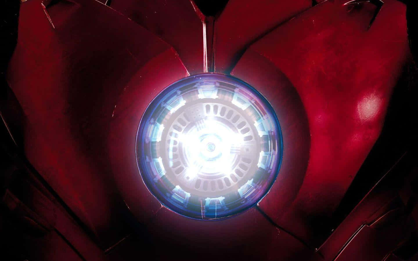 Iron Man Arc Reactor 桌布 壁紙 — 發光的藍色弧形反應堆在裝甲服的紅色金屬胸甲內脈動。