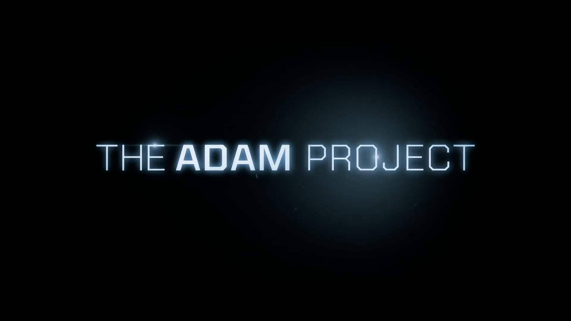 The Adam Project 桌布 壁紙 — 發光的藍色霓虹文字在深色背景上顯示「THE ADAM PROJECT」，帶有微弱的燈光暈染。